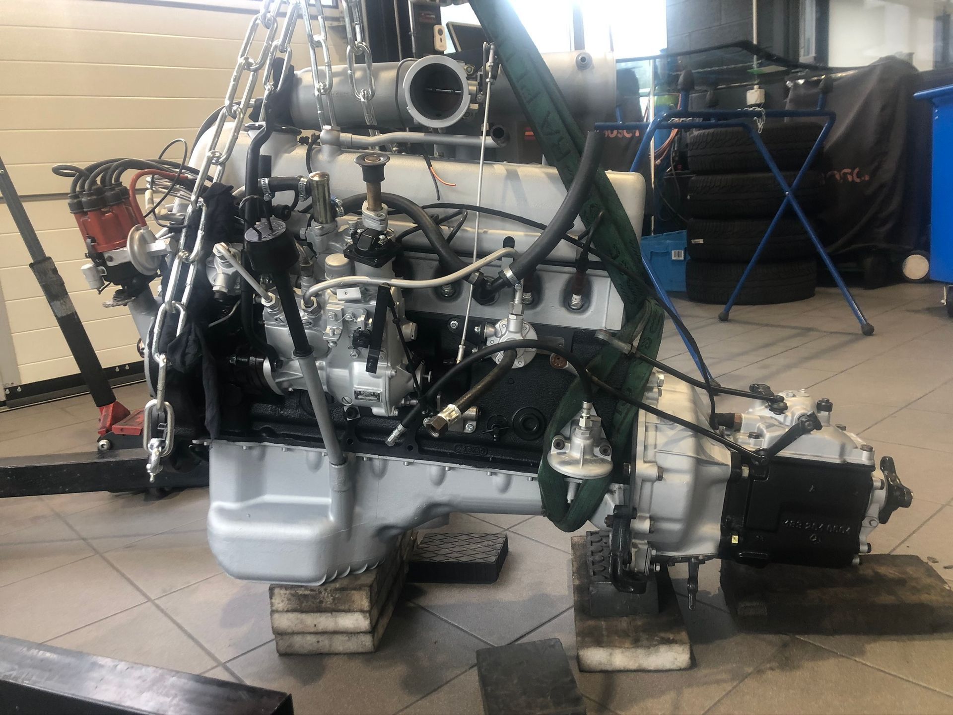 Un gros moteur repose sur des blocs dans un garage.