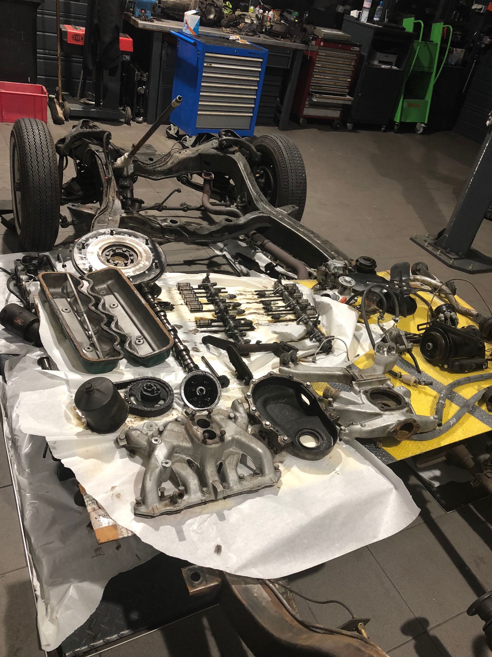 Un tas de pièces sont posées sur une table dans un garage.