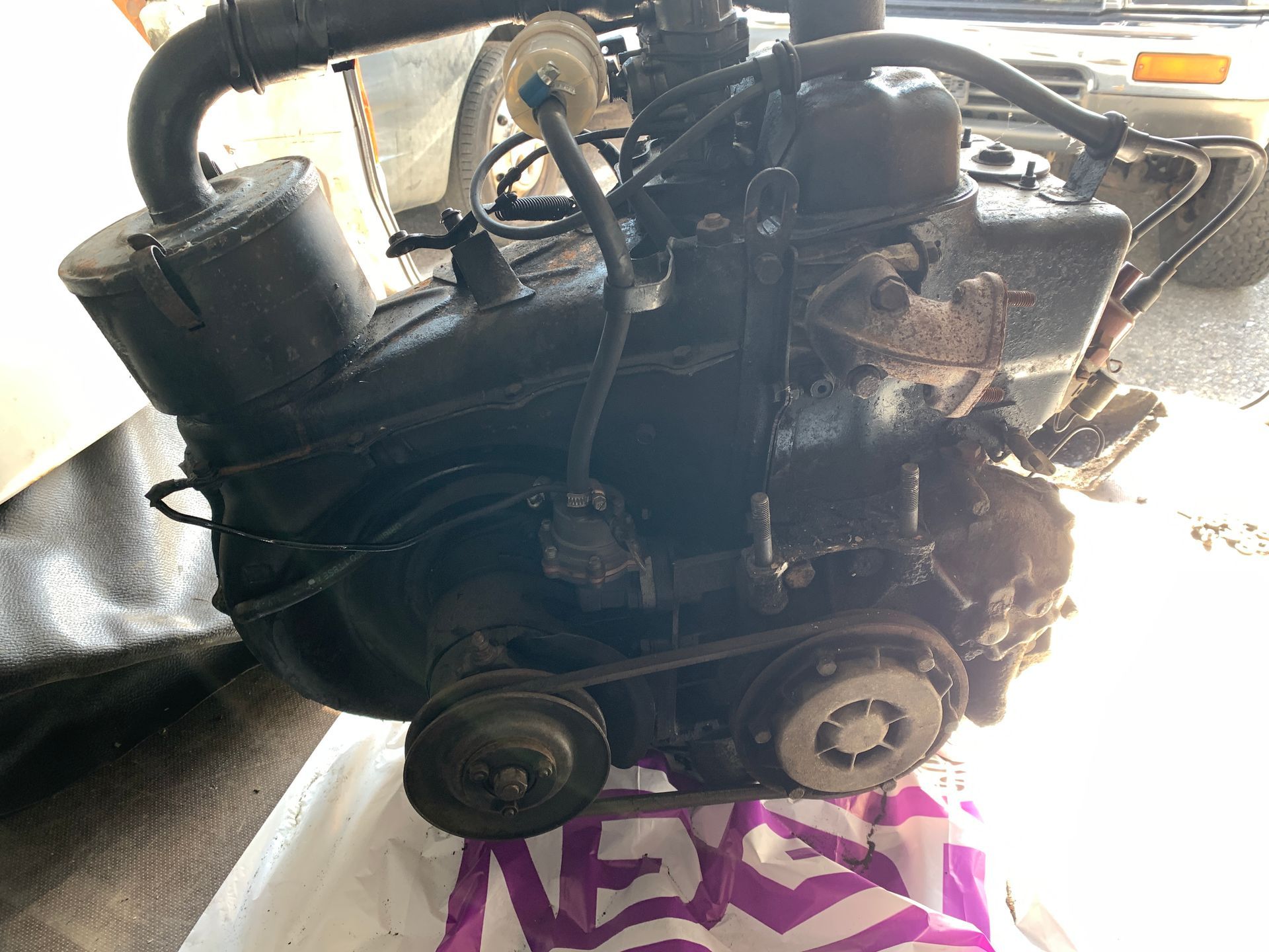 Un moteur noir est posé sur un sac violet.