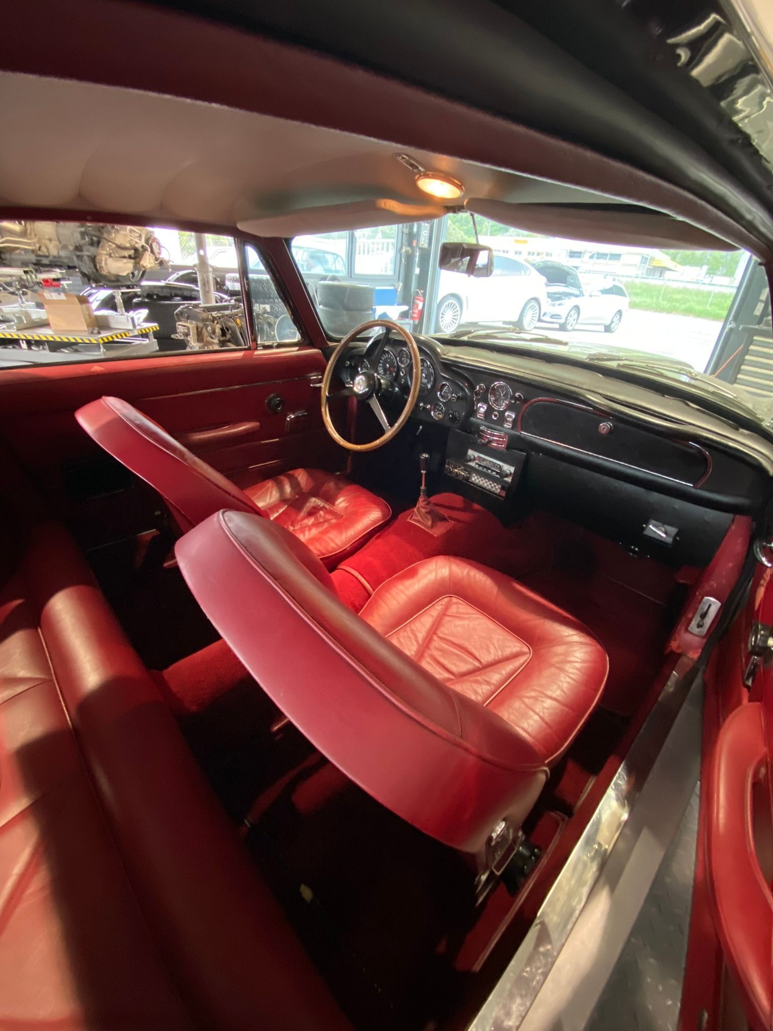 L'intérieur d'une voiture avec des sièges rouges et un volant.