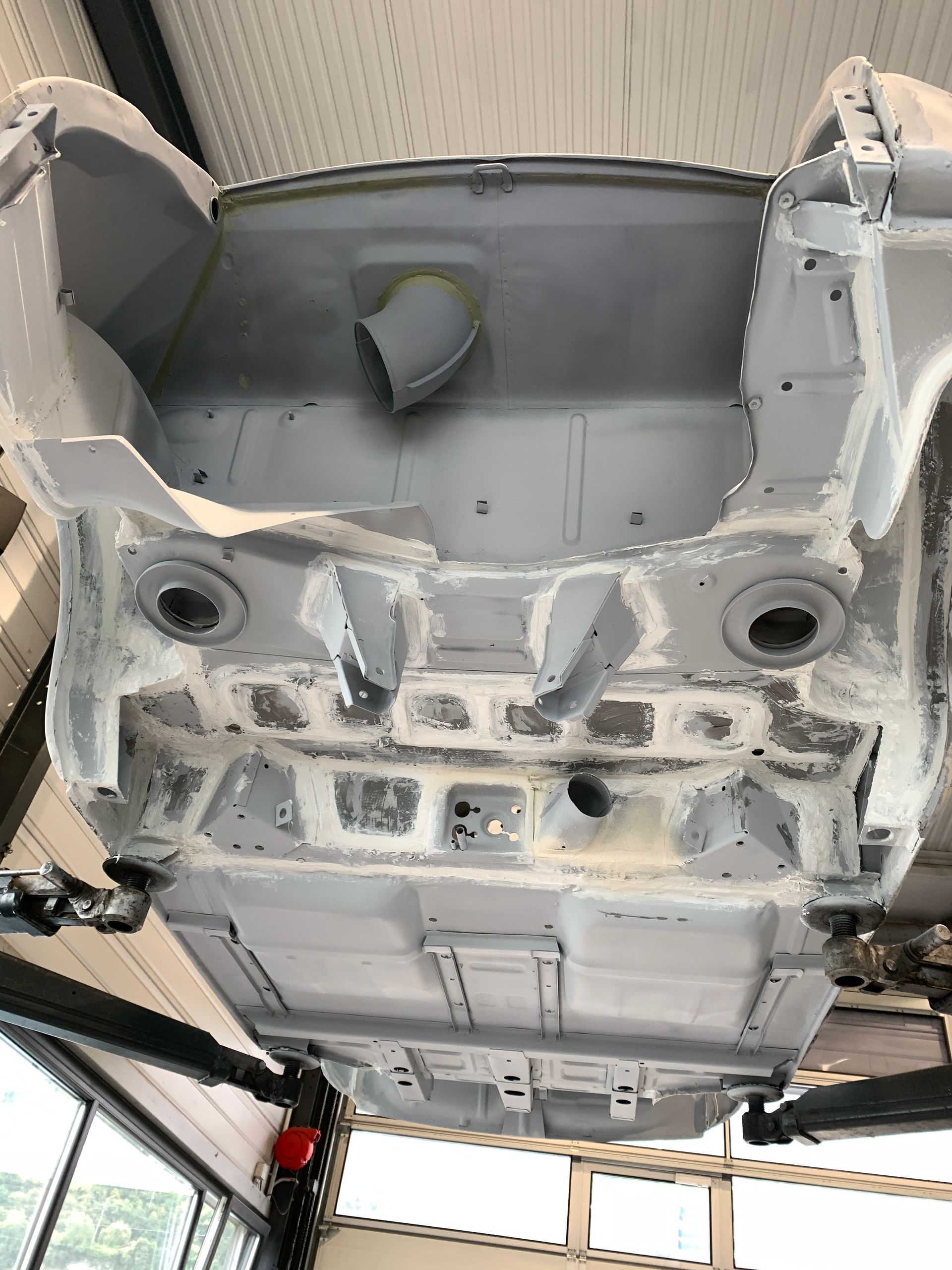 Le bas d'une voiture est peint dans un garage.