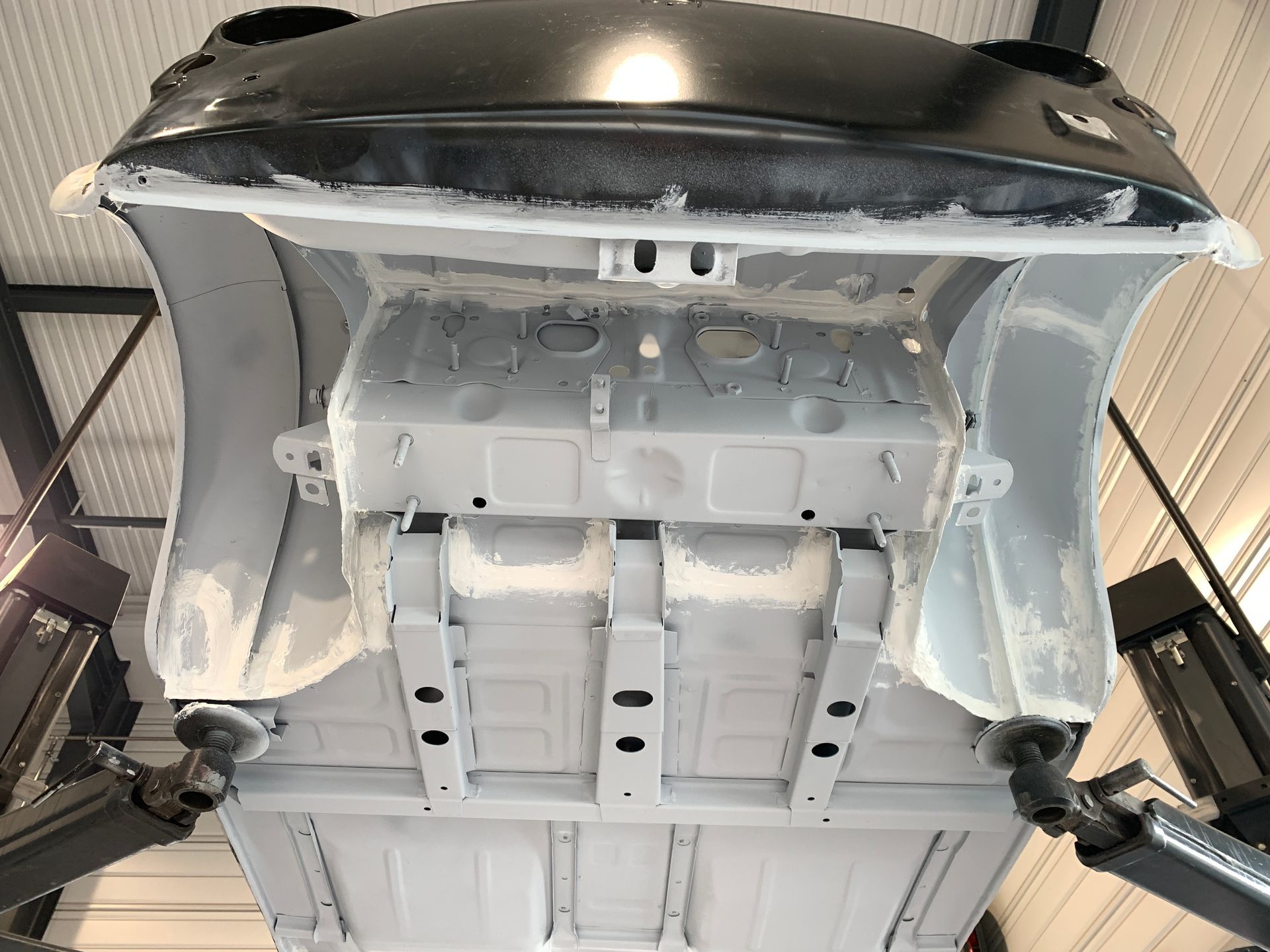 Le bas d’une voiture repose sur un ascenseur dans un garage.