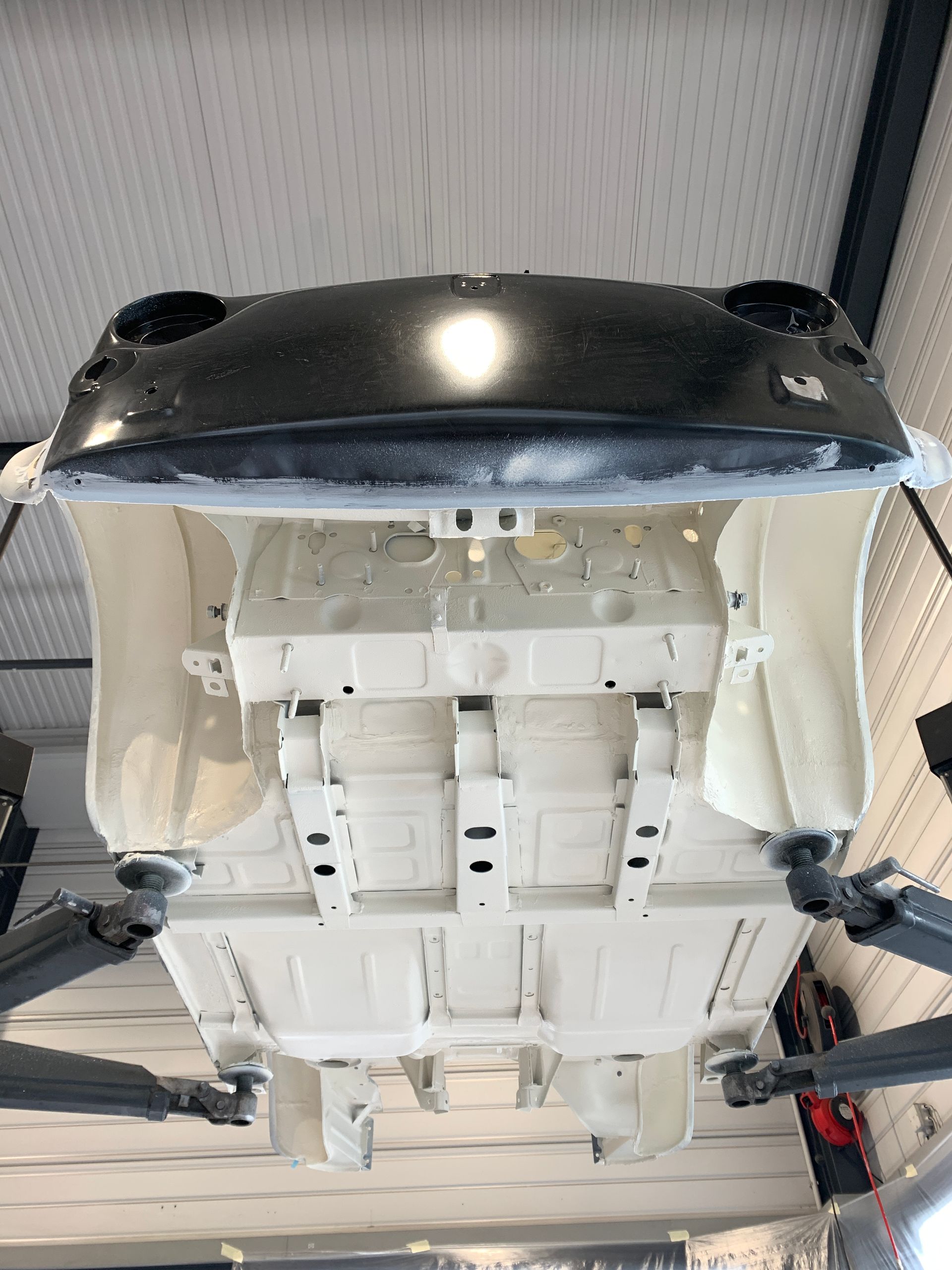 Le dessous d’une voiture repose sur un ascenseur dans un garage.