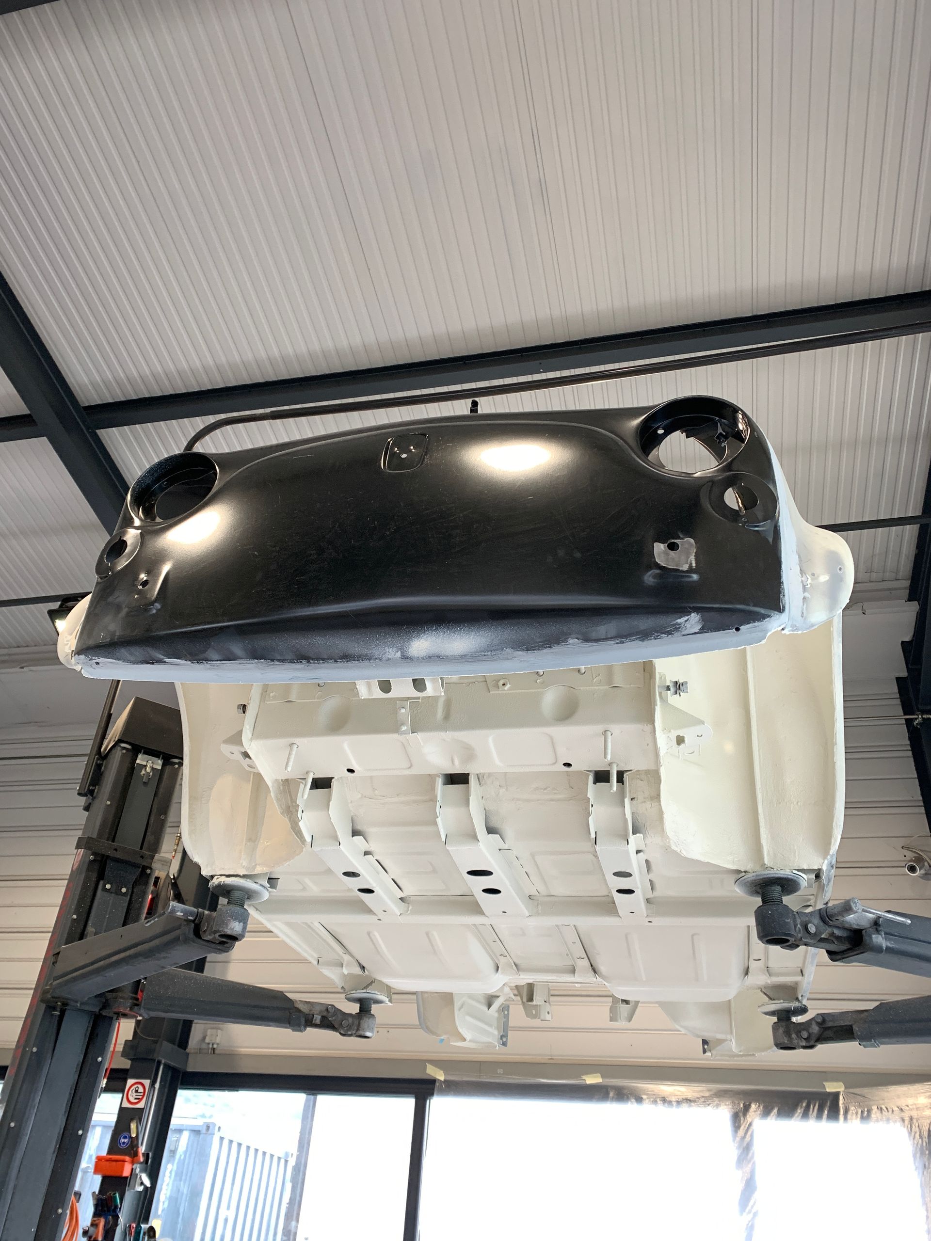 Une voiture est suspendue au plafond d'un garage.