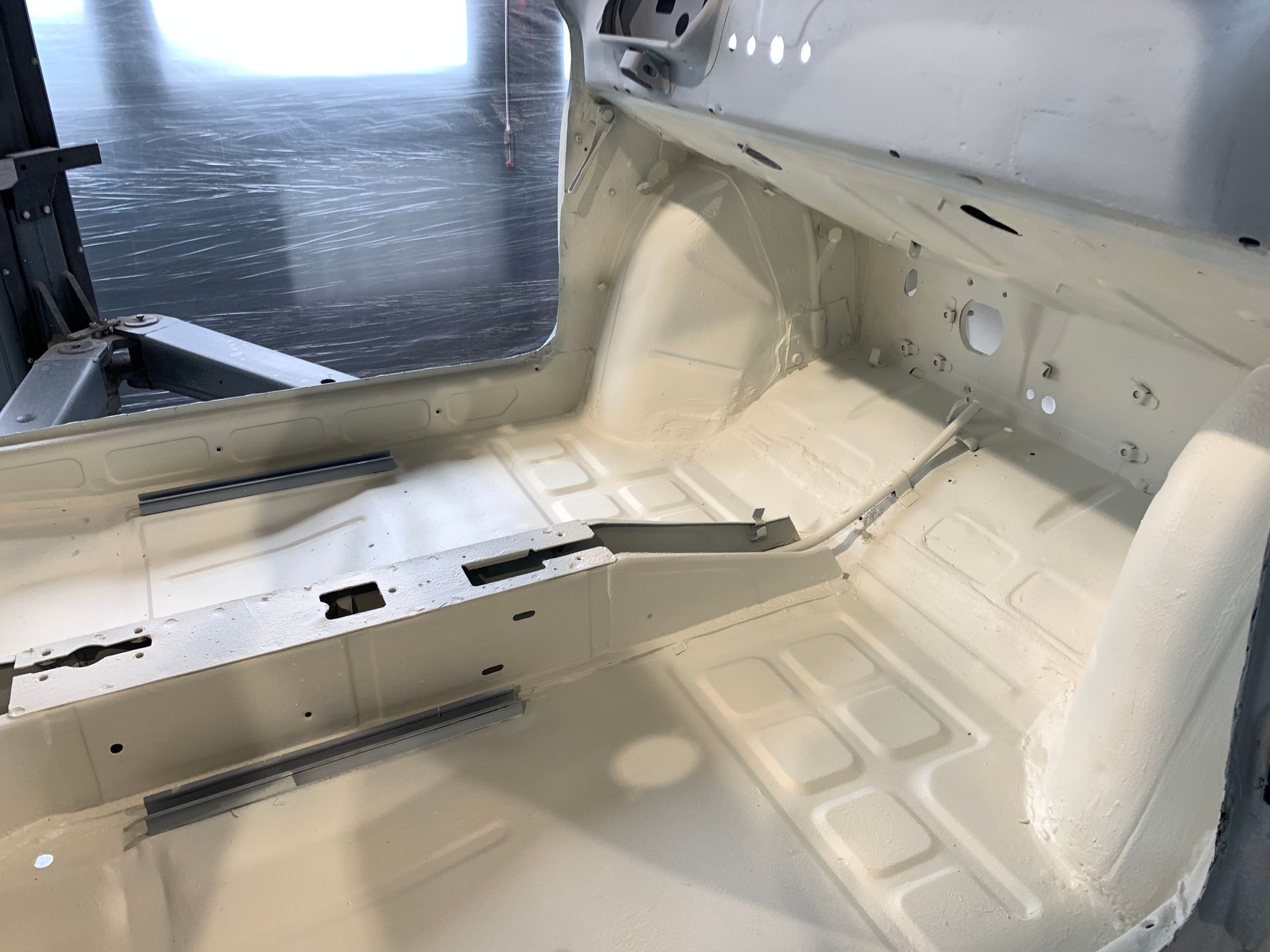 Une voiture blanche est posée sur un sol en béton.