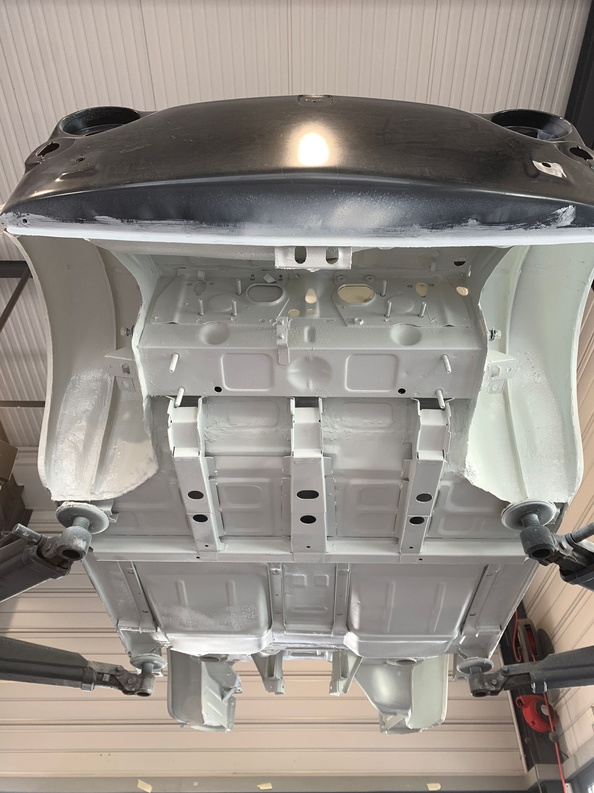 Le bas d'une voiture est peint dans un garage.