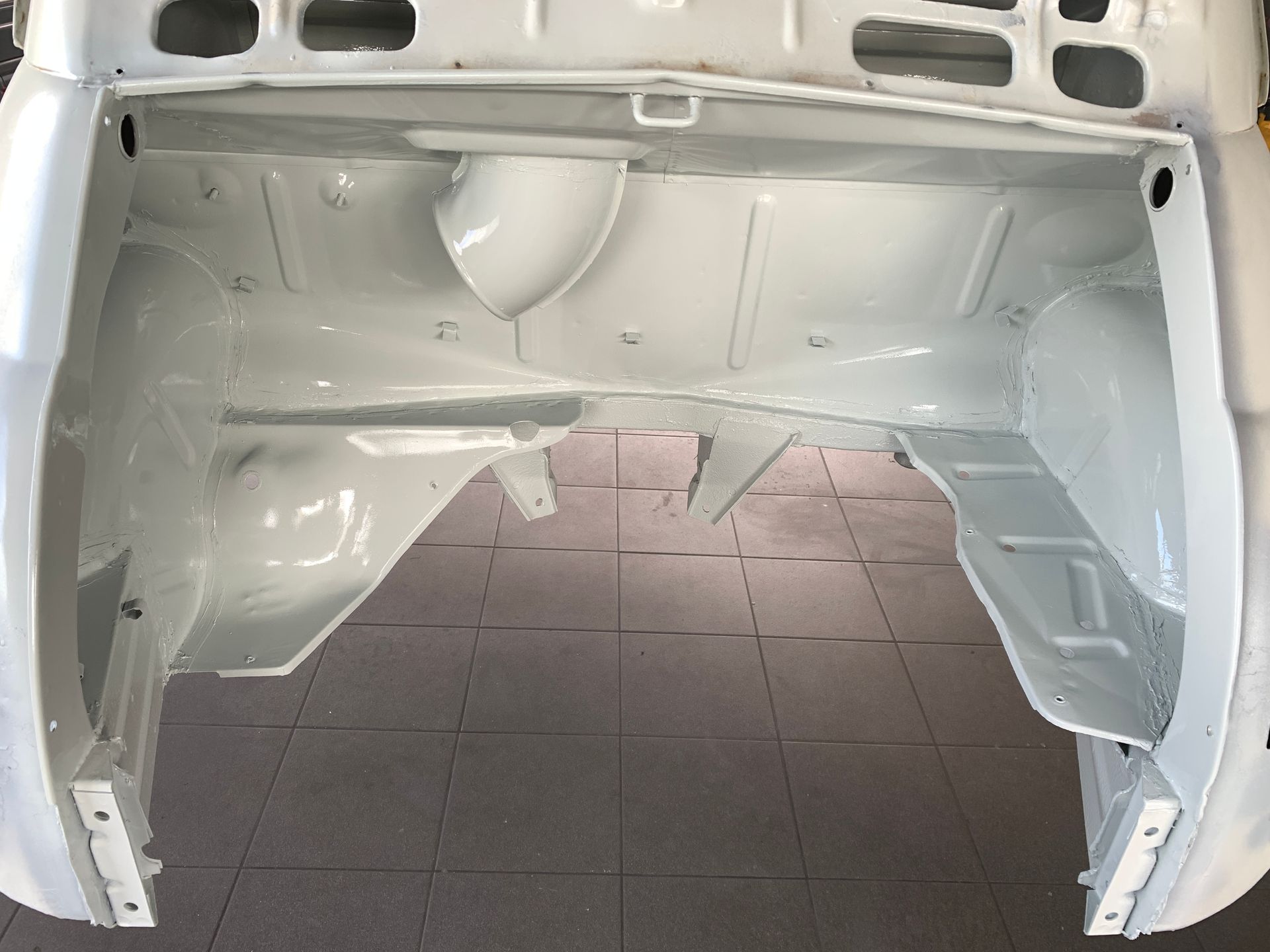 L'intérieur d'une voiture blanche avec le coffre ouvert