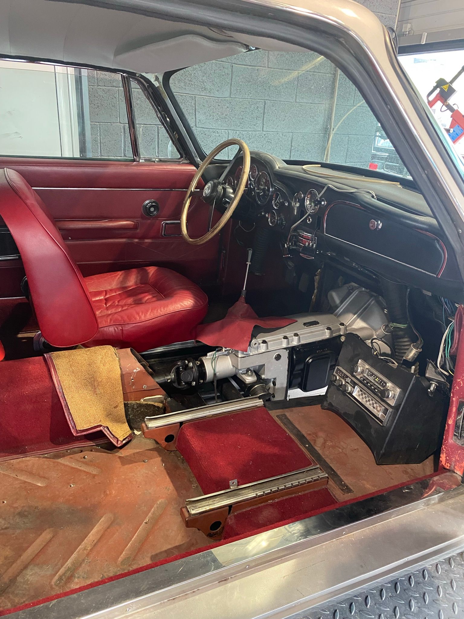 L'intérieur d'une voiture avec des sièges rouges et un volant.