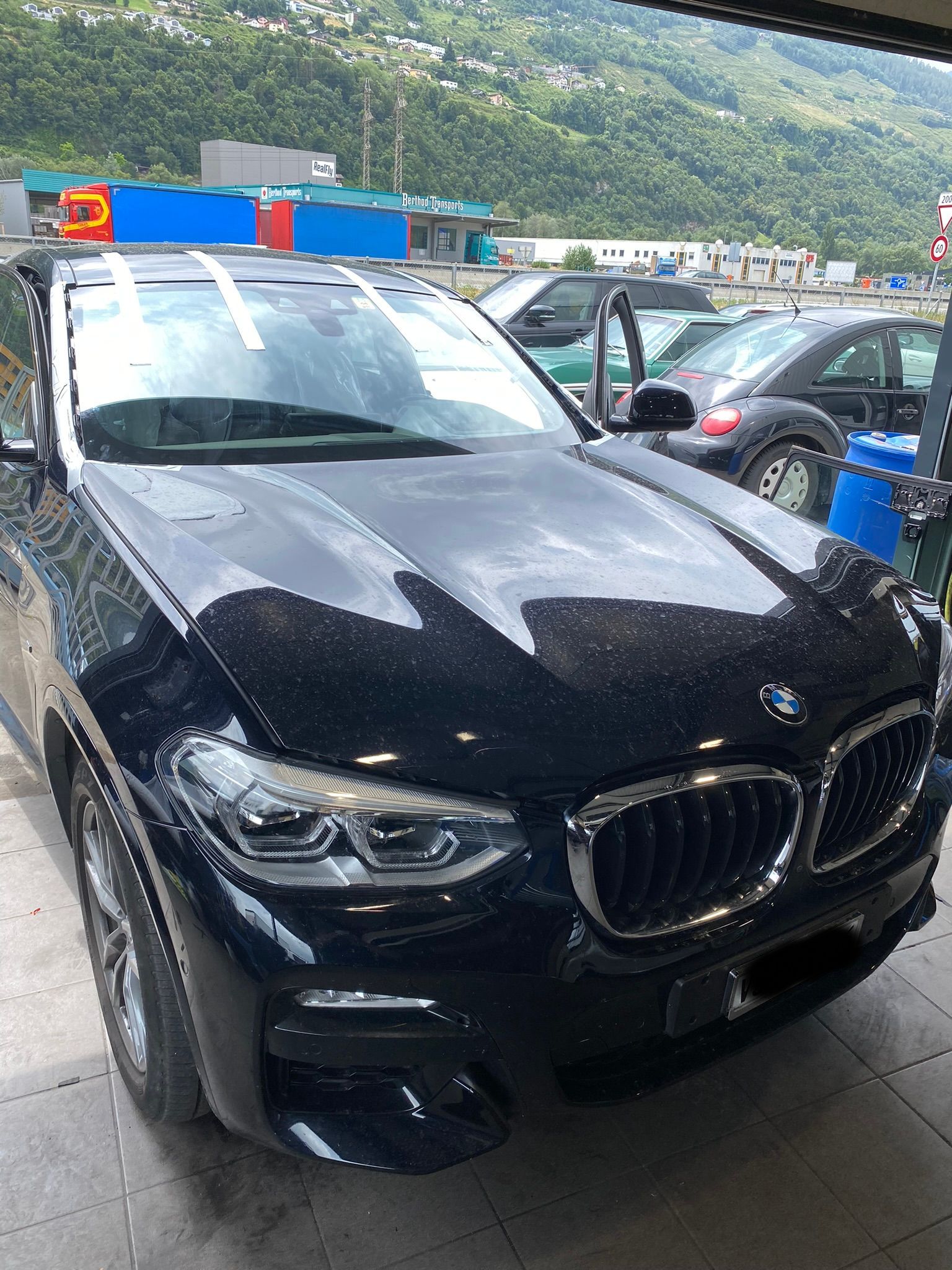 Une BMW X4 noire est garée dans un parking.