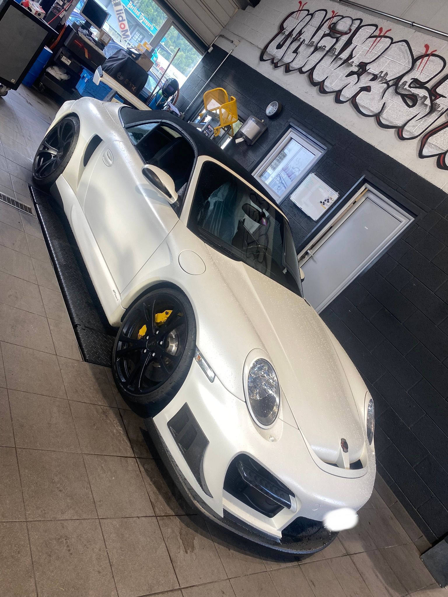 Une porsche 911 gt3 rs blanche est garée dans un garage.