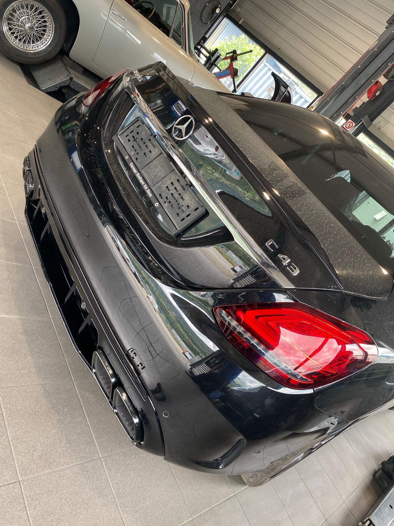 Une Mercedes Benz Classe C noire est garée dans un garage.