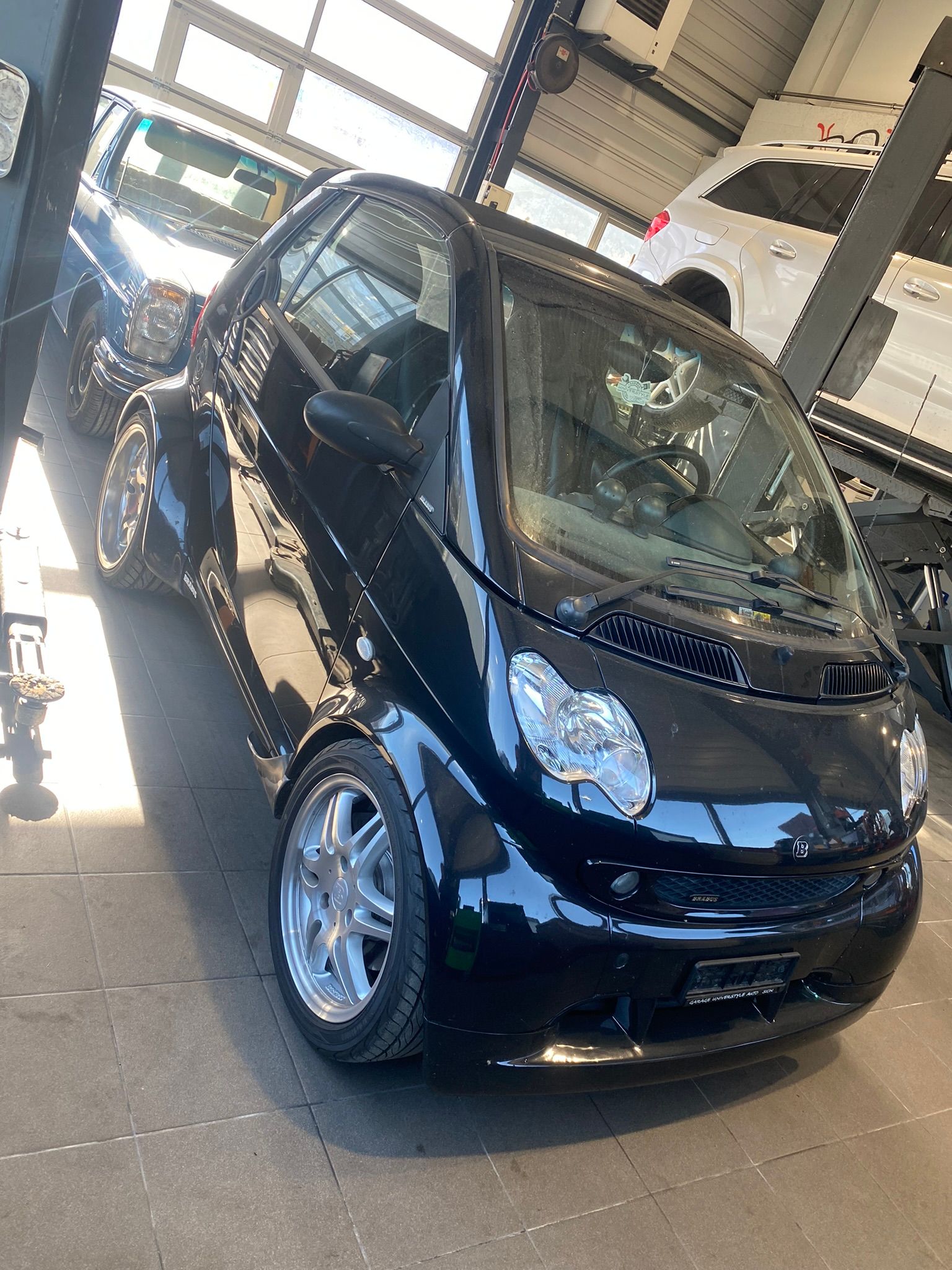 Une voiture intelligente noire est garée dans un garage.