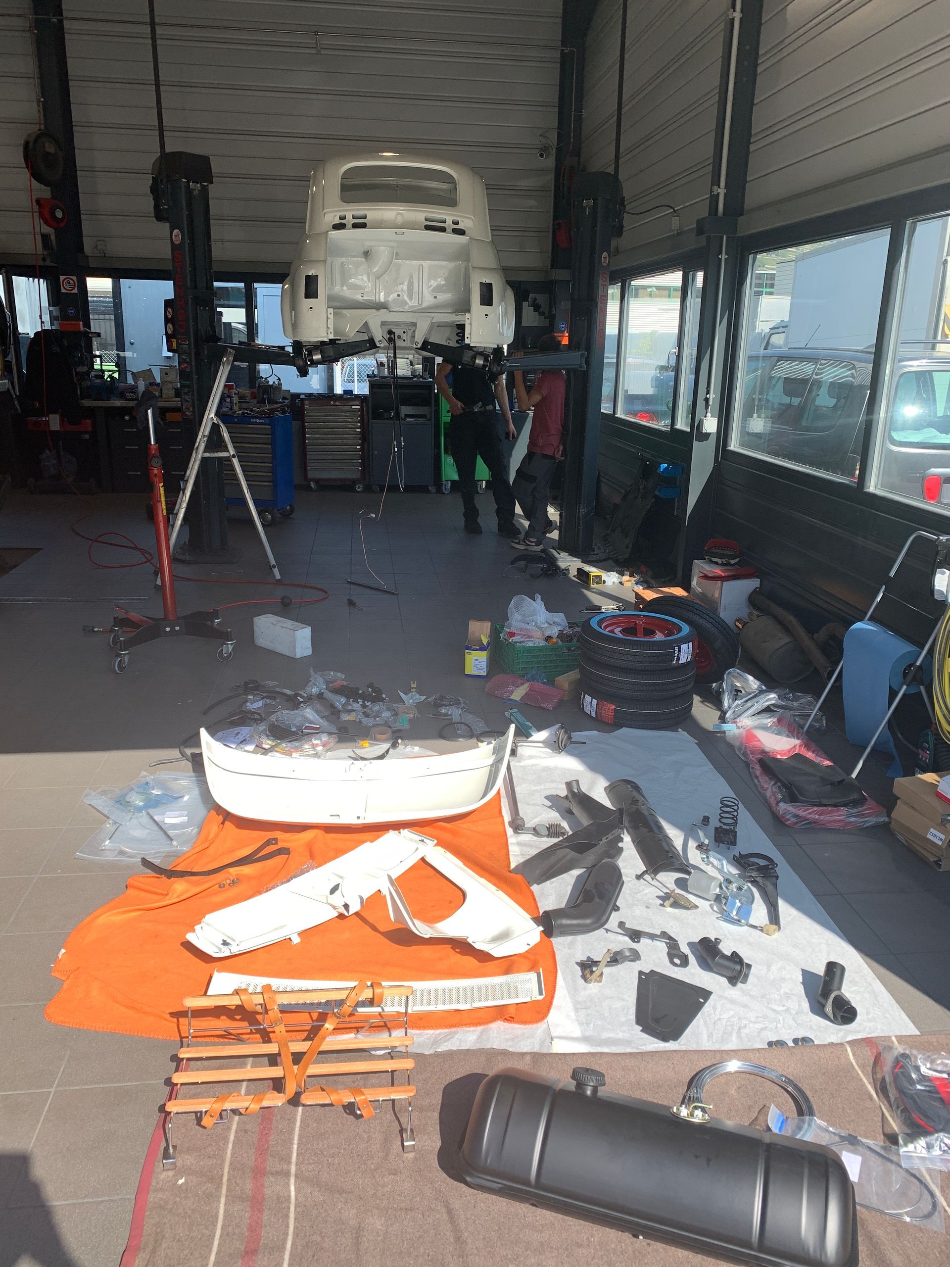 Une voiture blanche est assise sur un ascenseur dans un garage