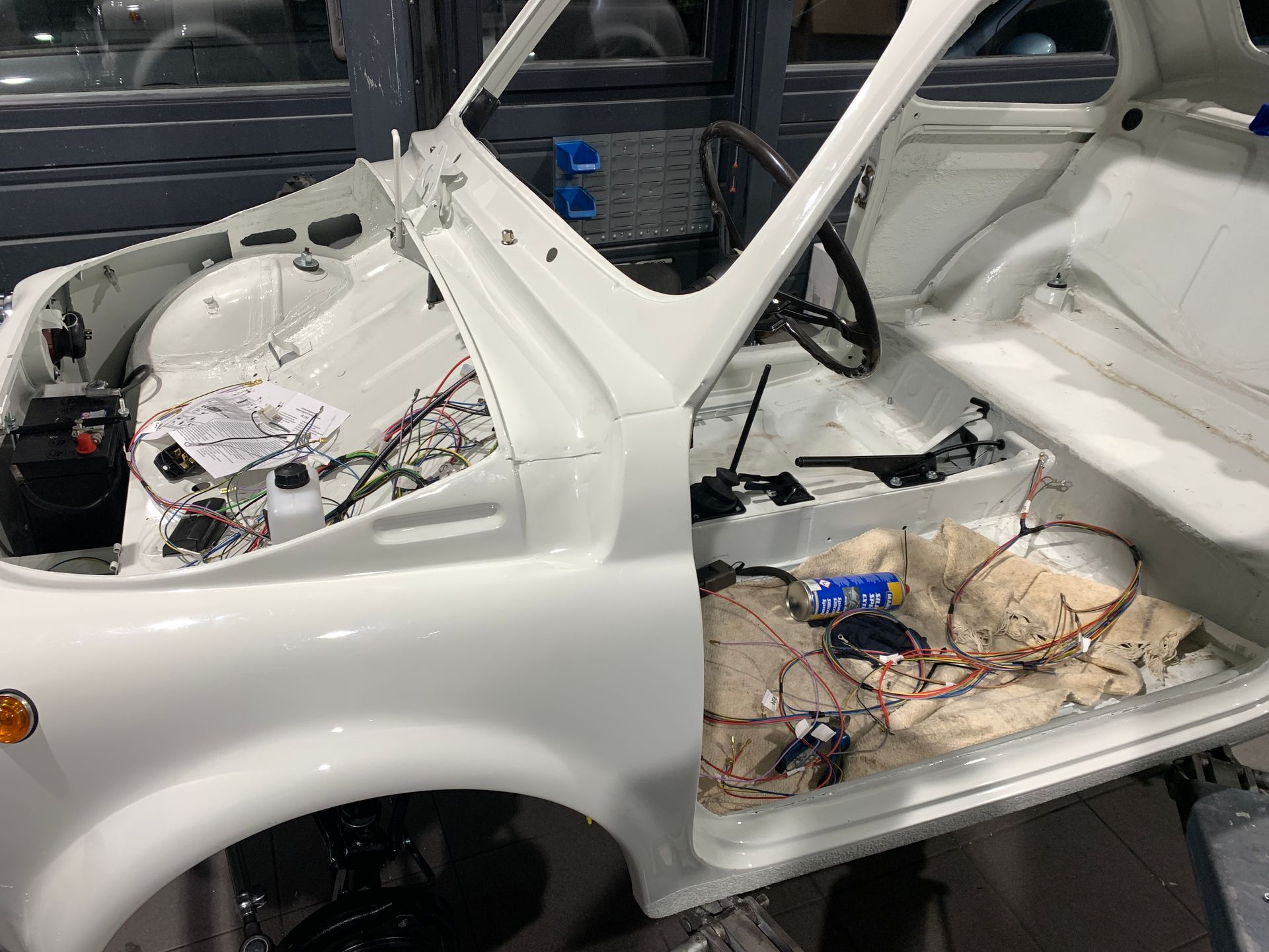 Une voiture blanche est construite avec le capot ouvert.