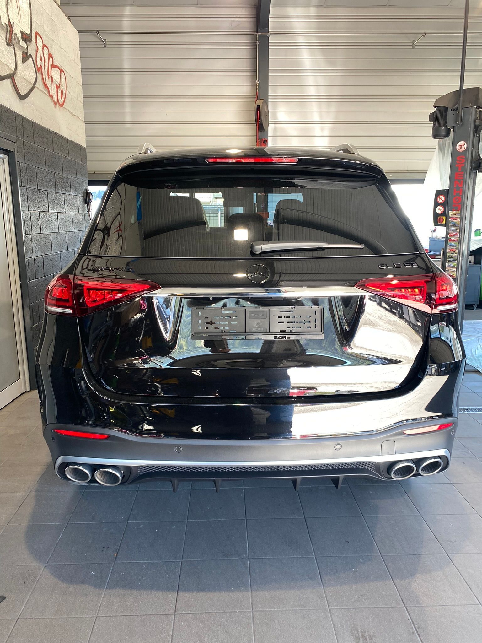 L'arrière d'une voiture noire est garée dans un garage.