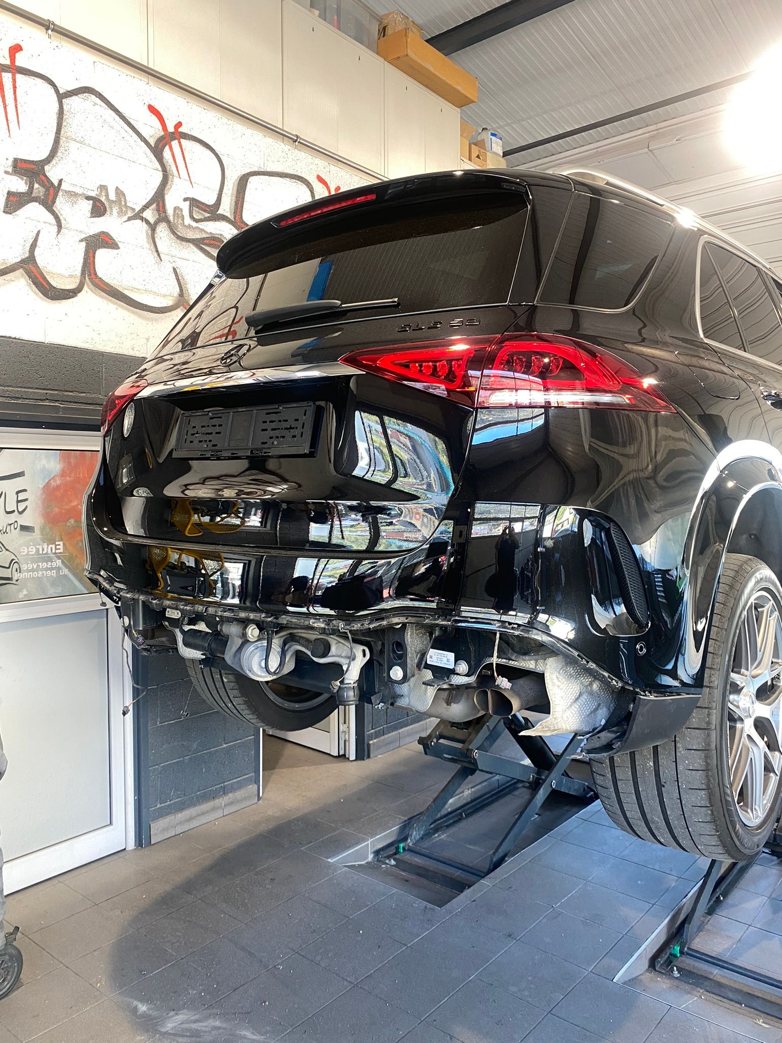 Une voiture est posée sur un ascenseur dans un garage.