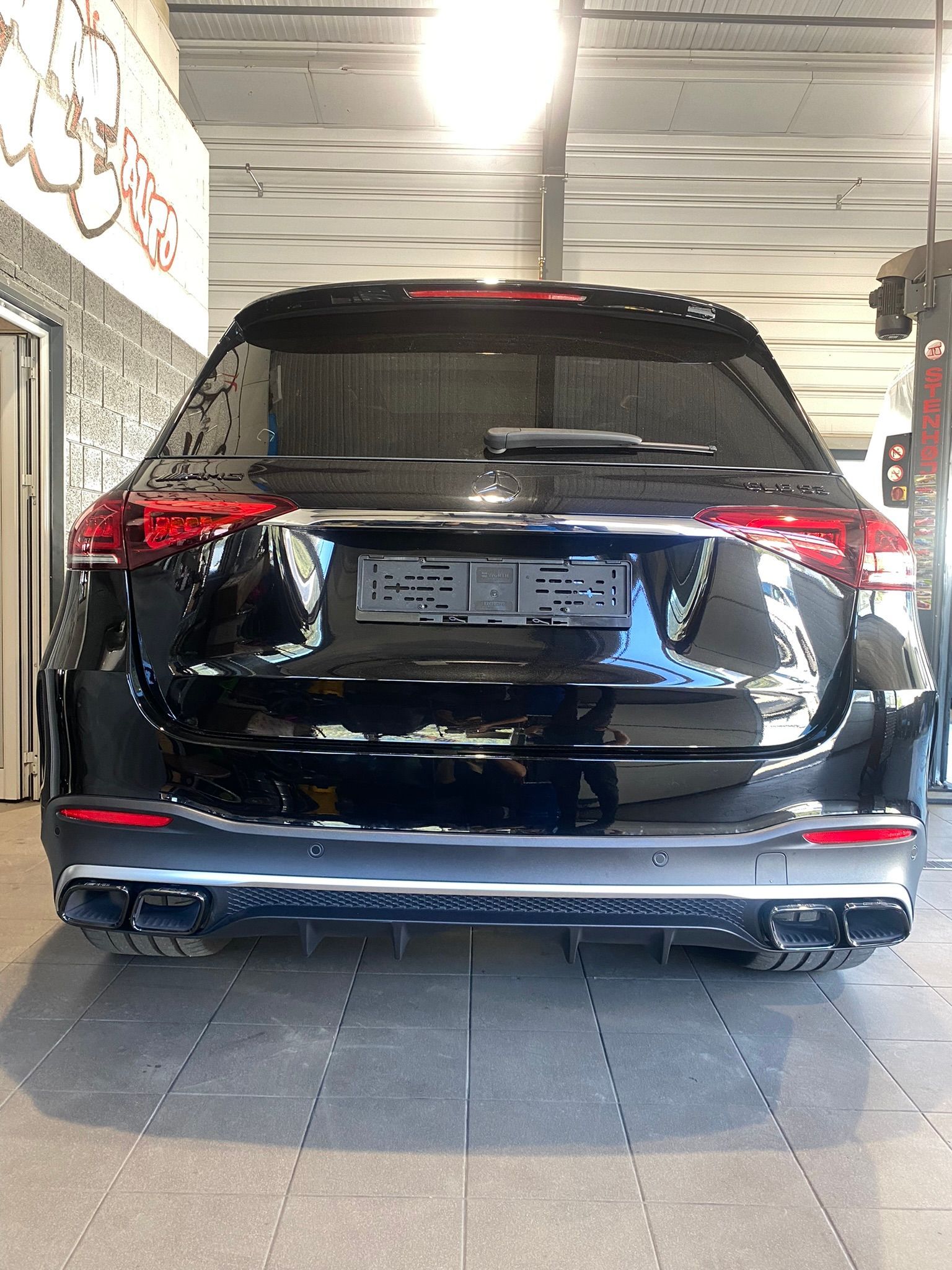 Une voiture noire est garée dans un garage.