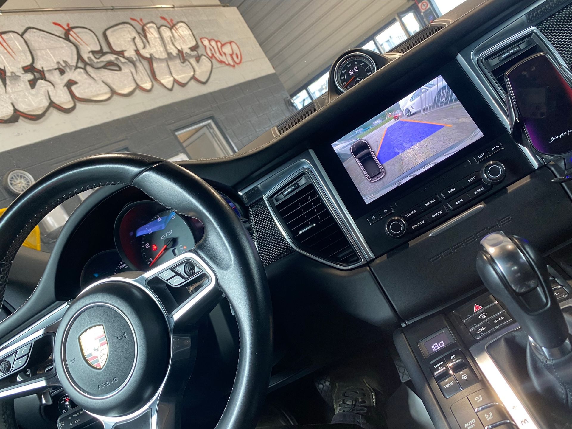 L'intérieur d'une voiture avec des graffitis sur le mur derrière elle