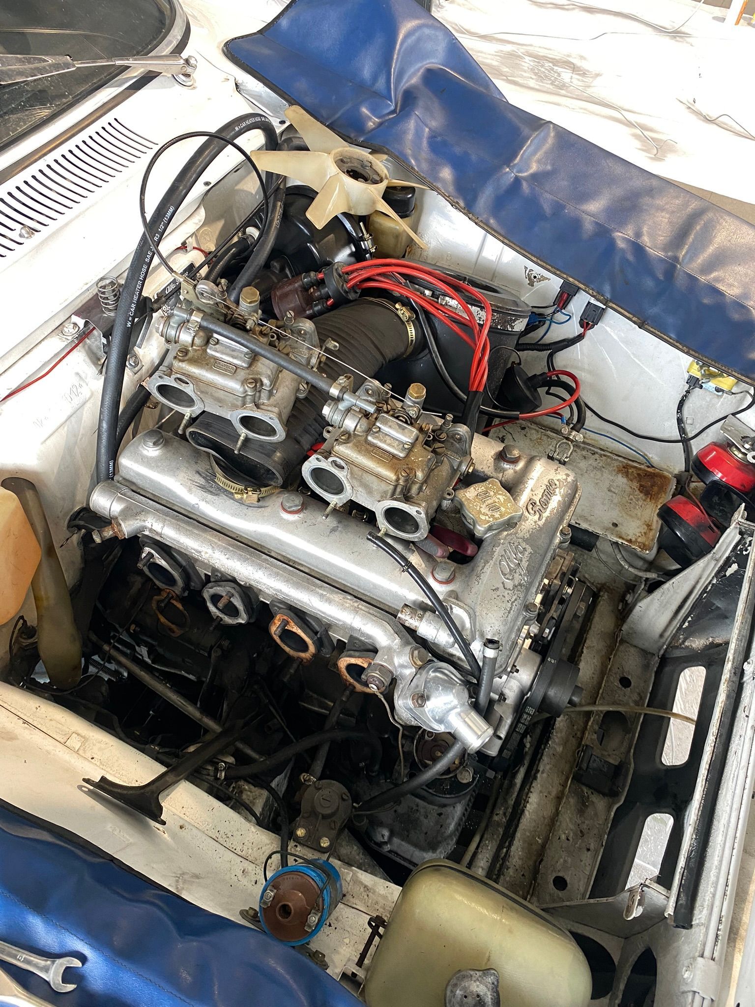 Un gros plan d'un moteur de voiture avec le capot ouvert.