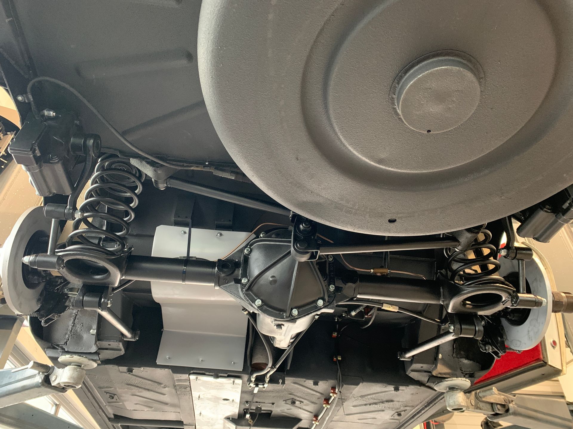 Un gros plan du dessous d’une voiture avec un gros pneu.