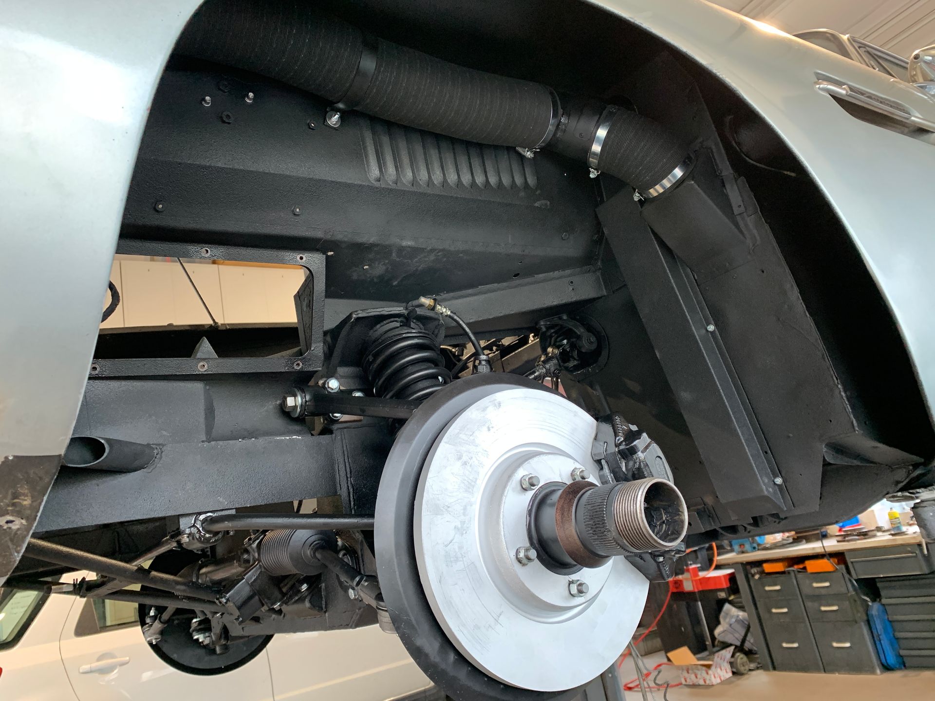 Un gros plan du dessous d’une voiture avec un disque de frein dessus.