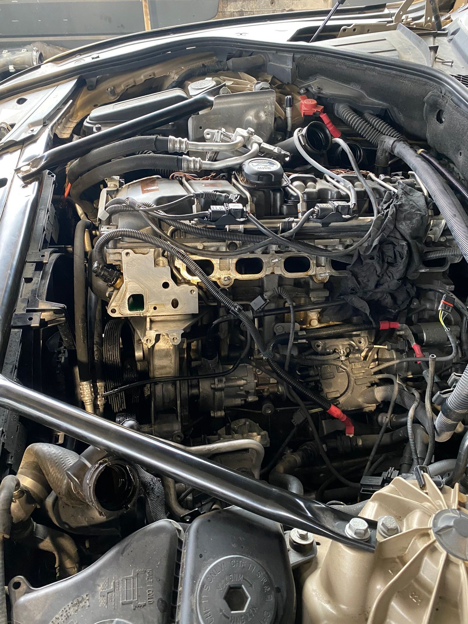 Un gros plan d'un moteur de voiture avec le capot ouvert.