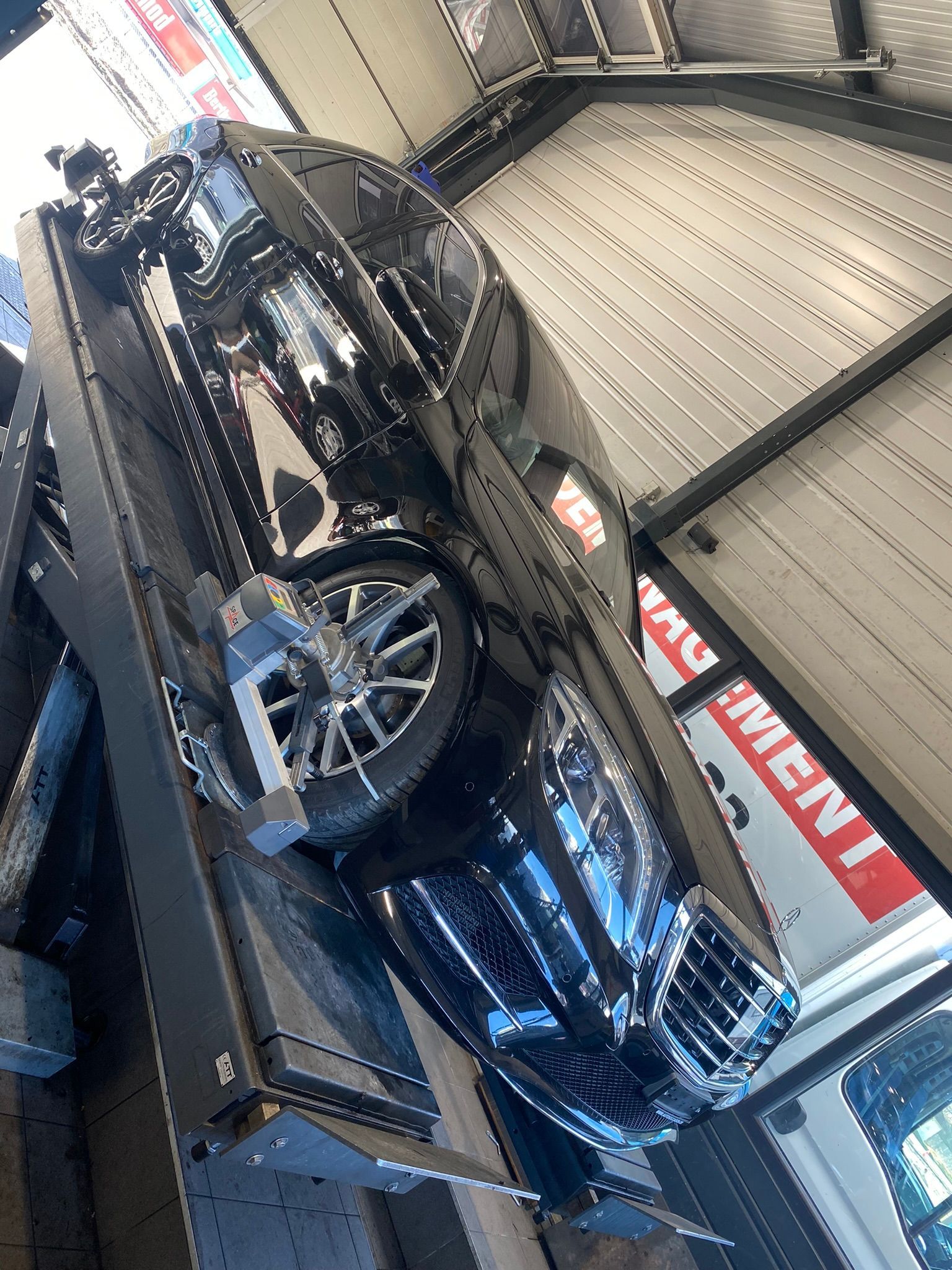 Une voiture noire est assise sur une dépanneuse.