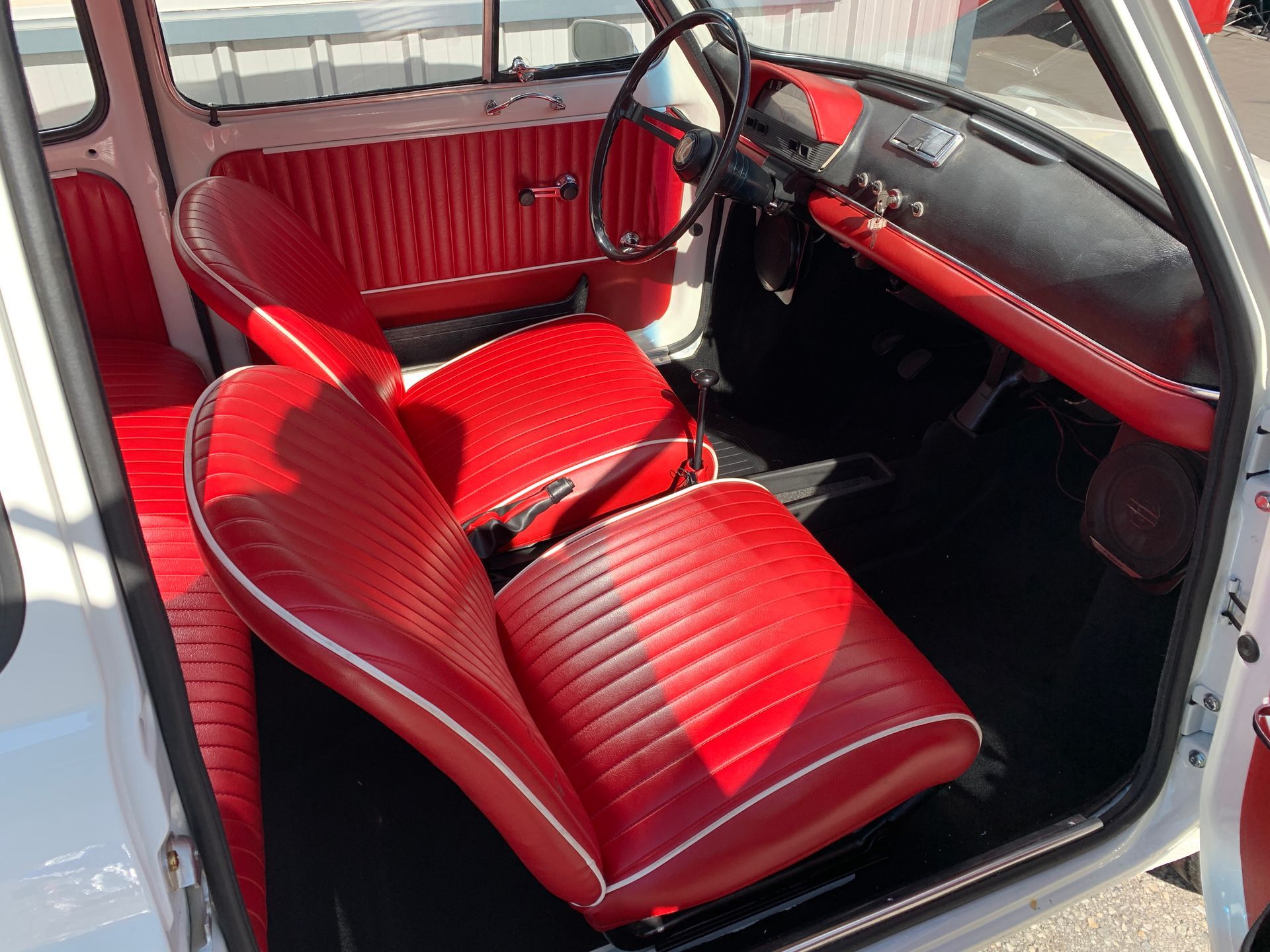 L'intérieur d'une voiture blanche avec des sièges rouges