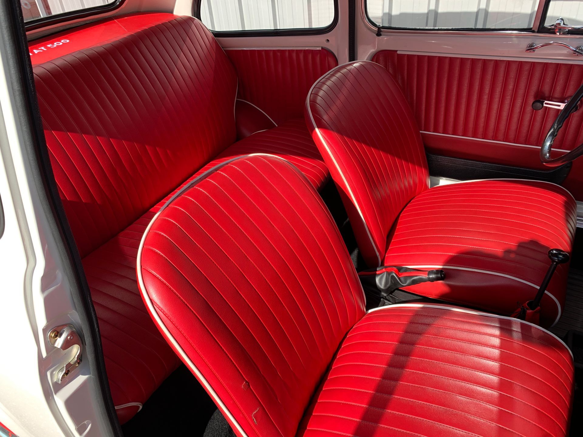 L'intérieur d'une voiture blanche avec des sièges rouges.