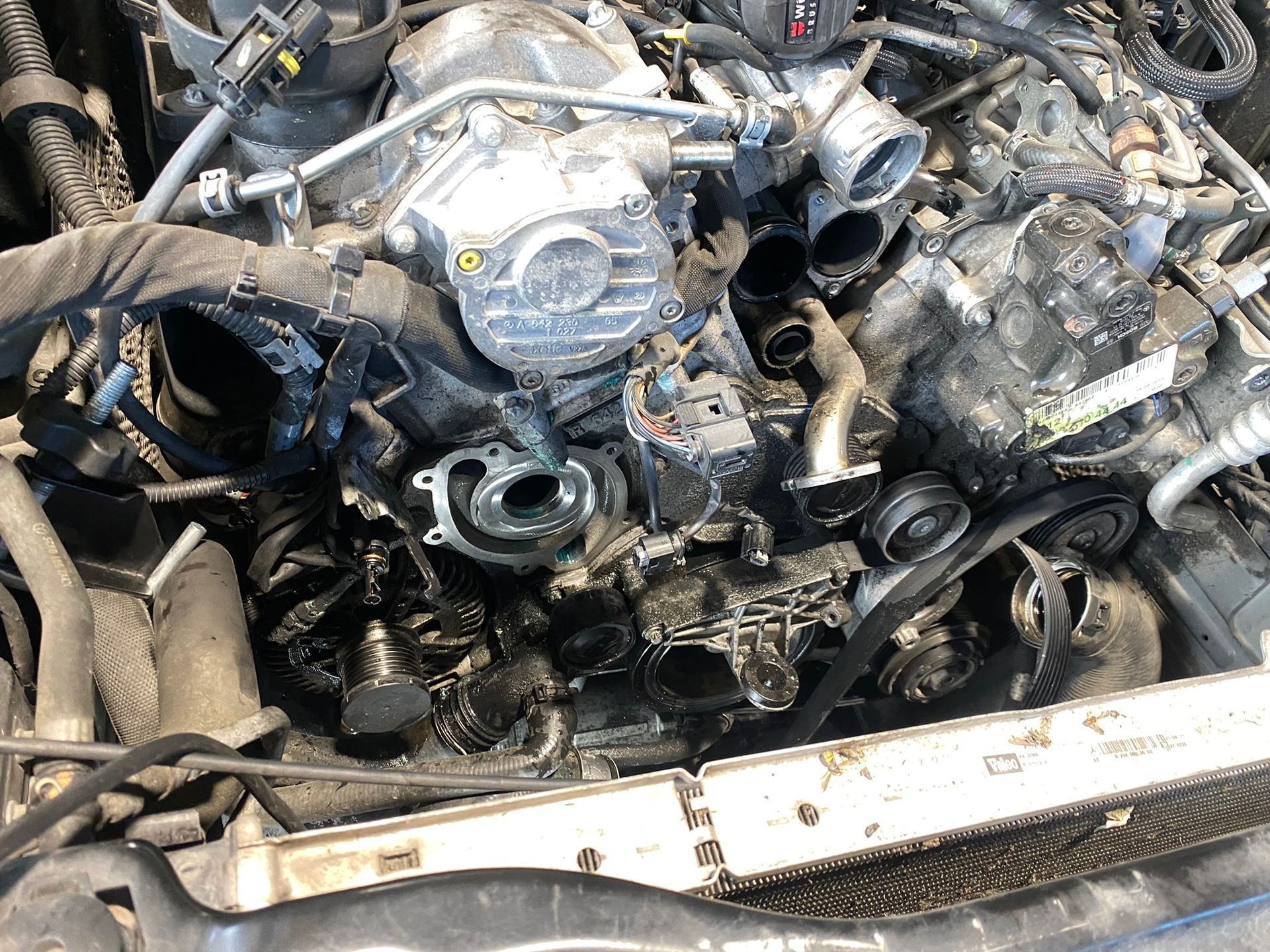 Un gros plan d'un moteur de voiture avec le capot ouvert.