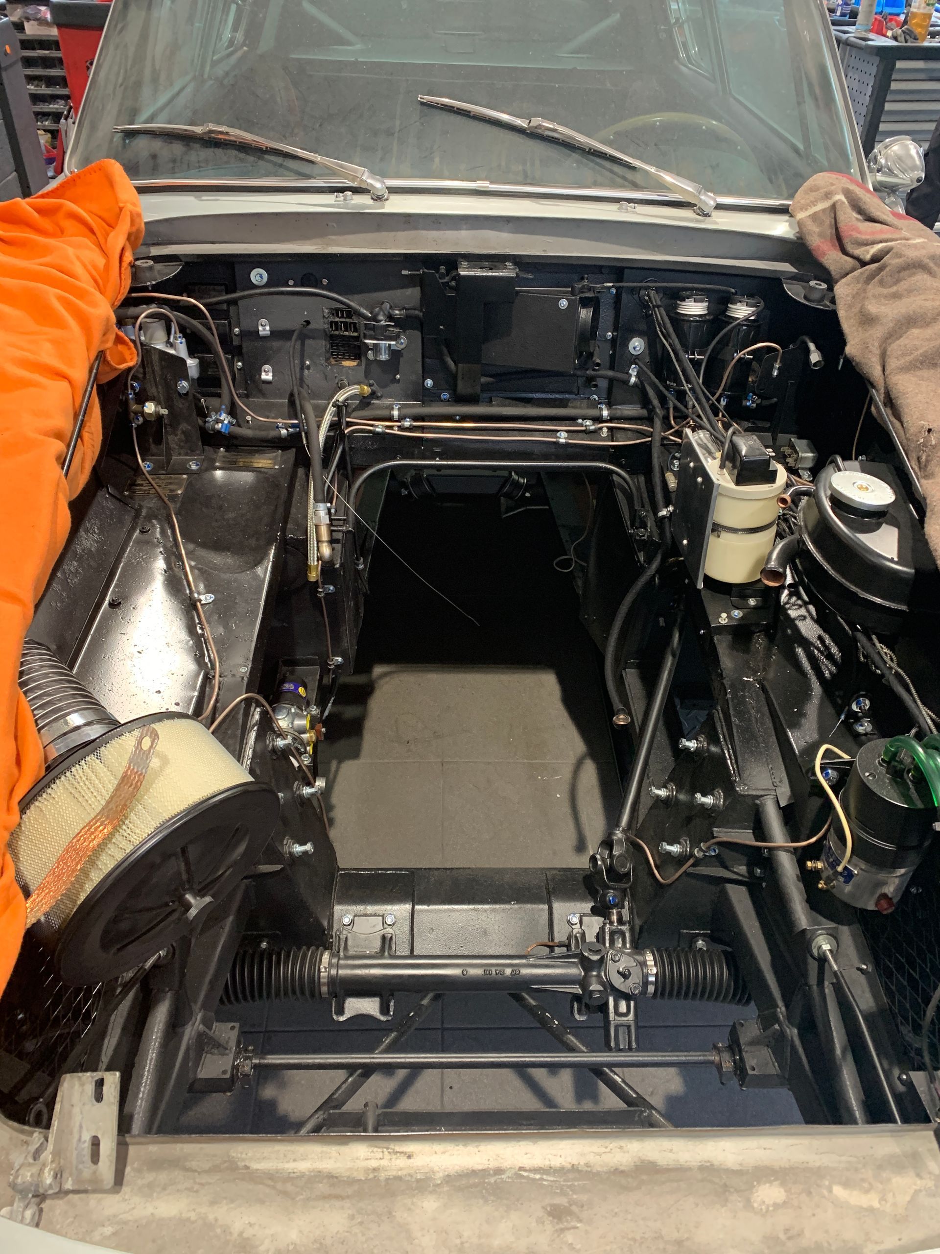 Le capot d'une voiture est ouvert et le moteur est visible.