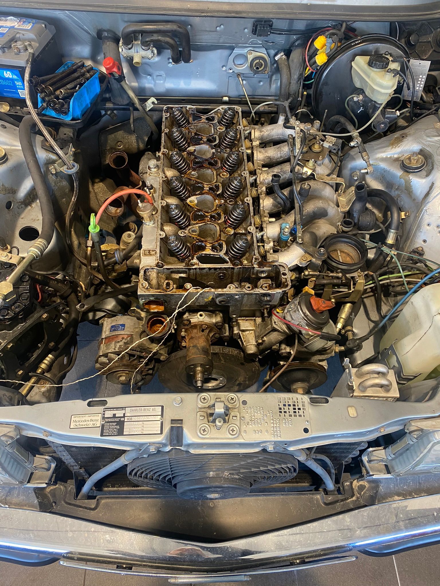 Un gros plan d'un moteur de voiture avec le capot ouvert.