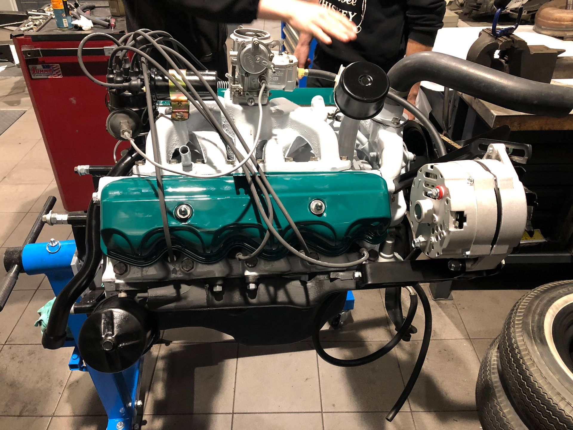 Un homme travaille sur un moteur de voiture dans un garage.