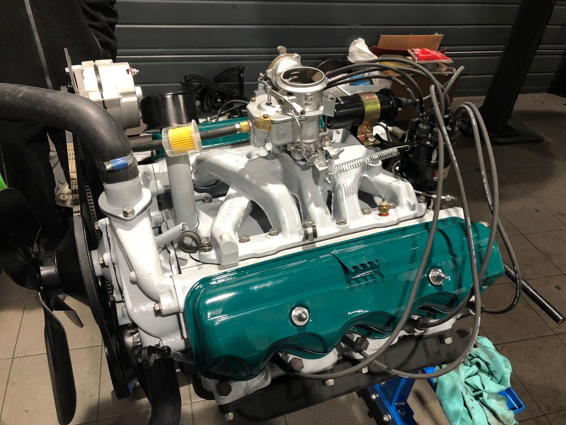 Un moteur de voiture est posé sur une table dans un garage.