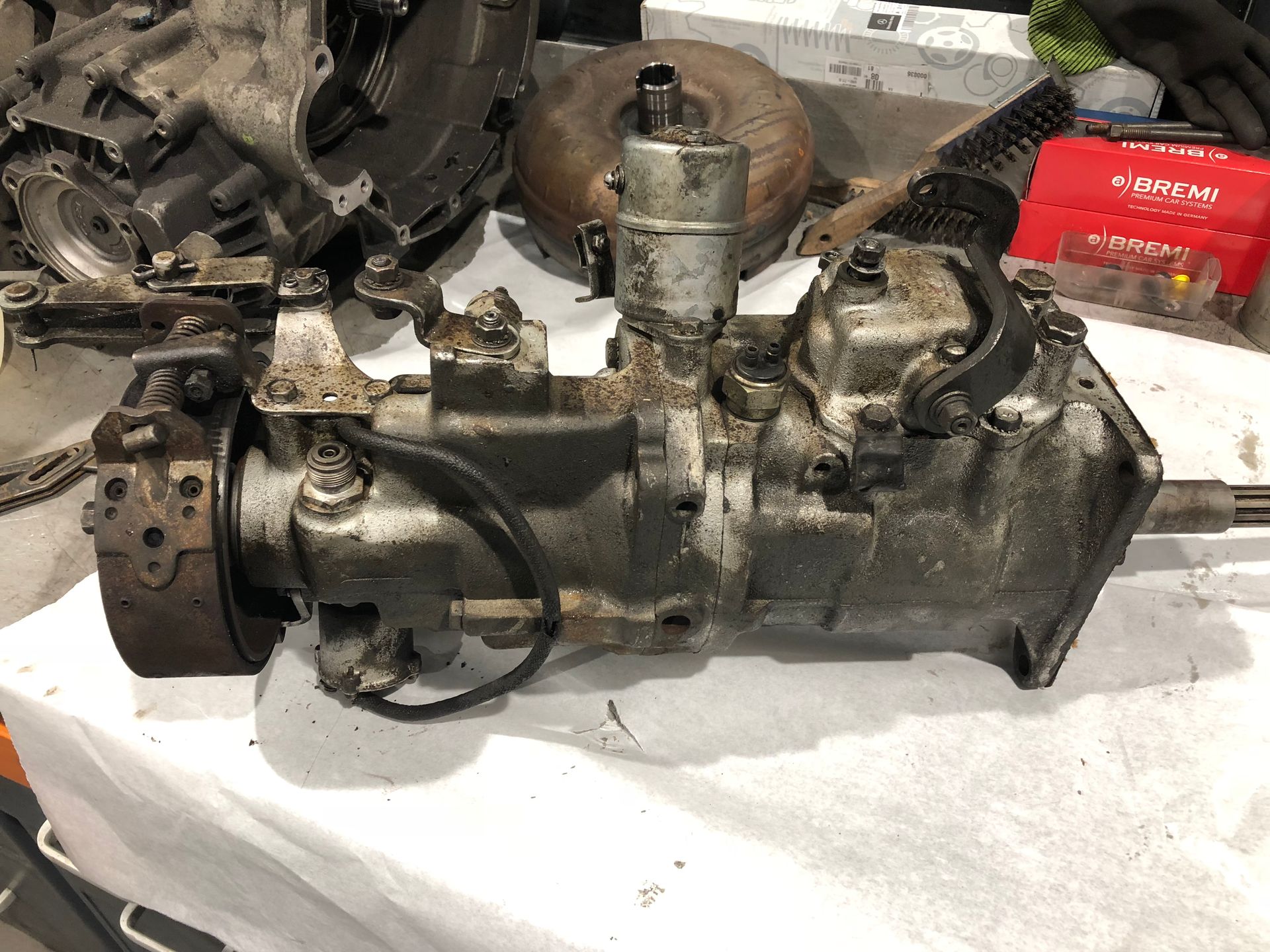 Une boîte de vitesses est posée sur un tissu blanc sur une table.