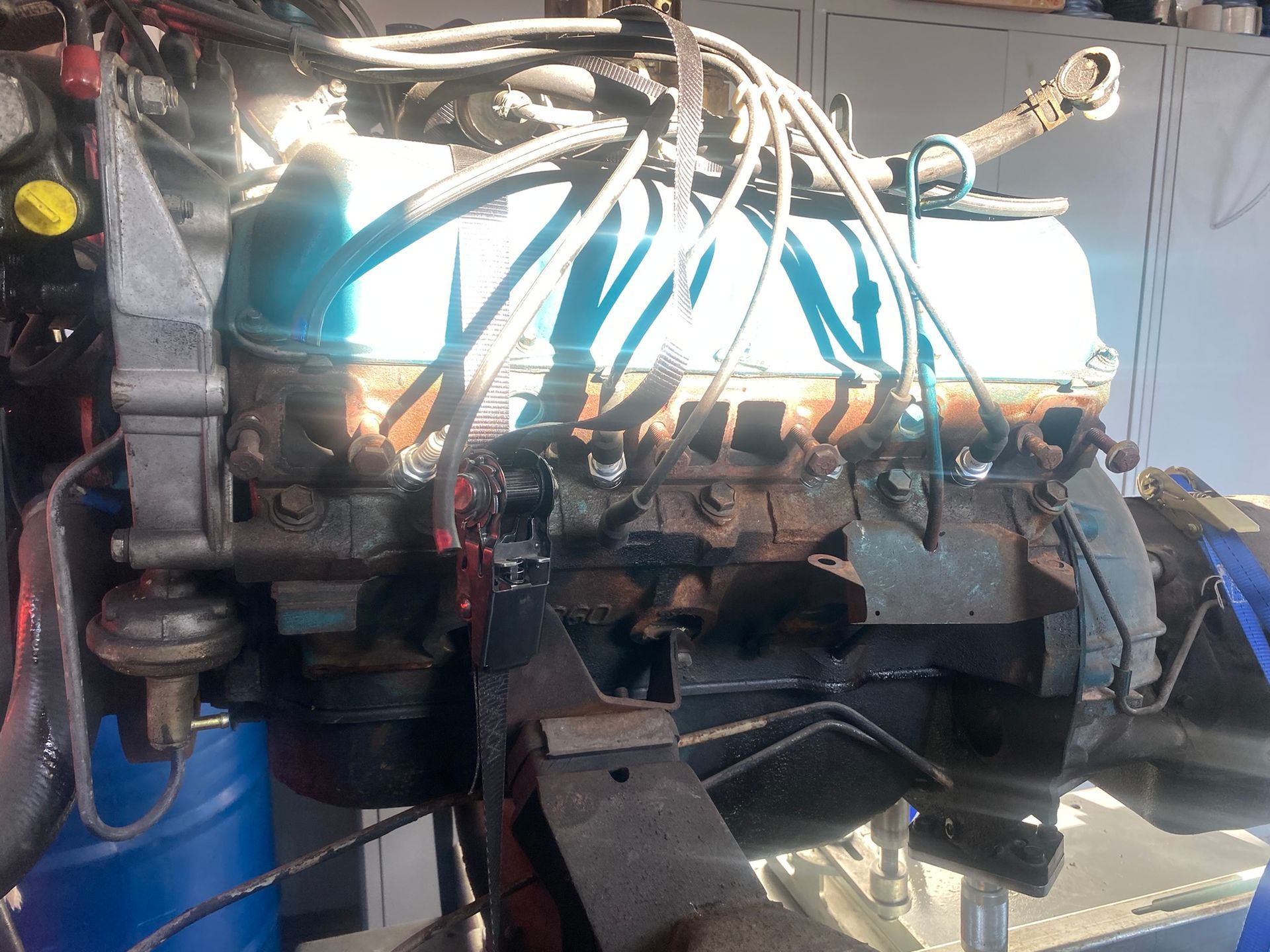 Un moteur de voiture est posé sur un baril bleu