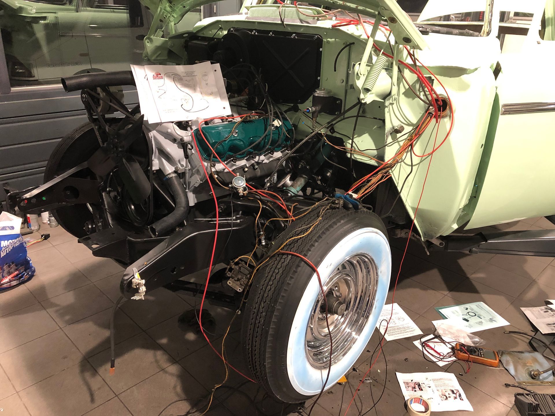 Une voiture verte est en cours de construction dans un garage.