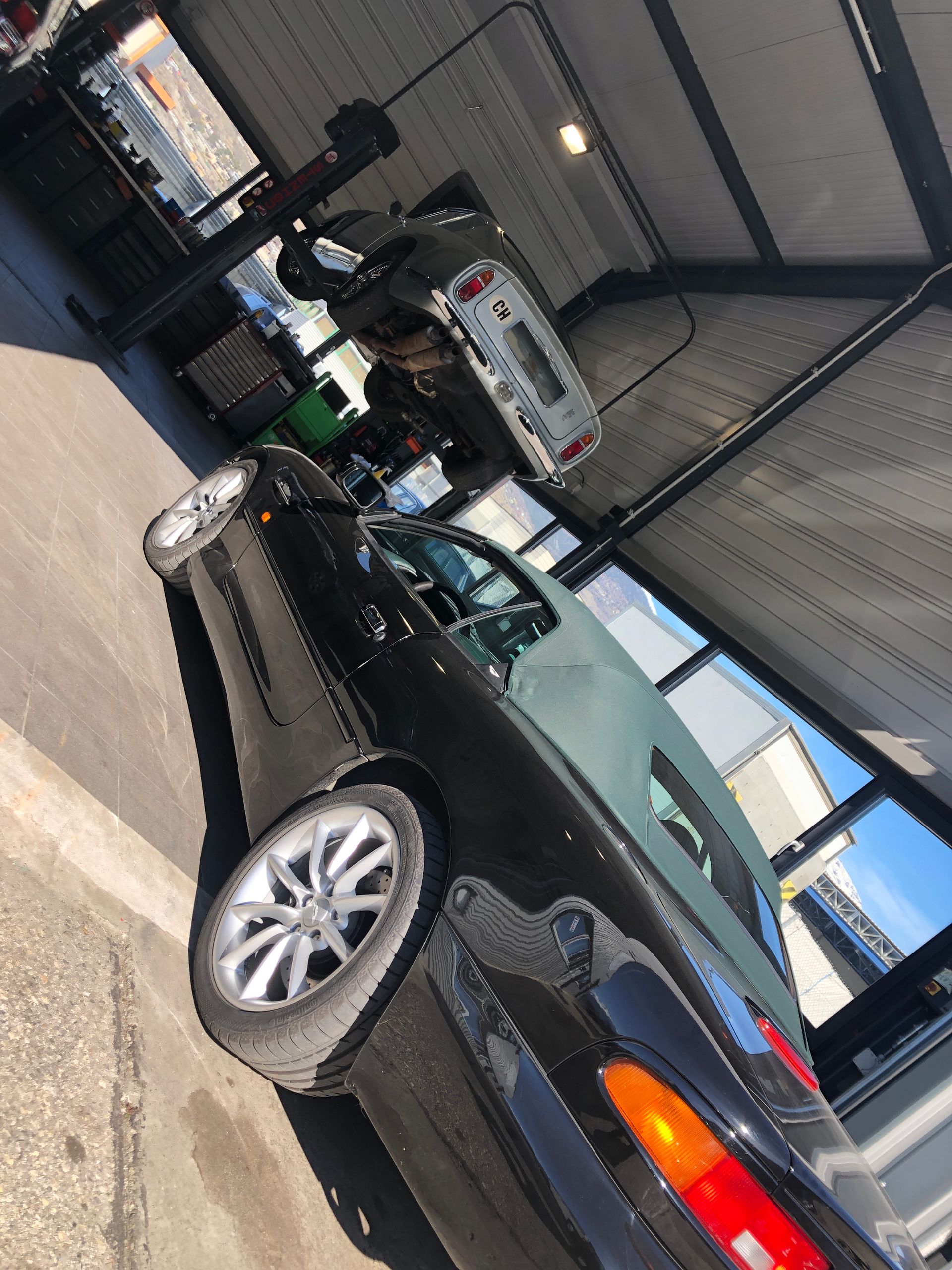 Une voiture noire est garée dans un garage avec le capot relevé