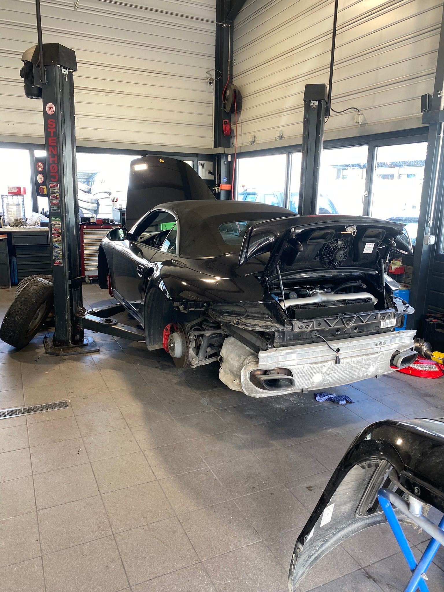 Une voiture est posée sur un ascenseur dans un garage.