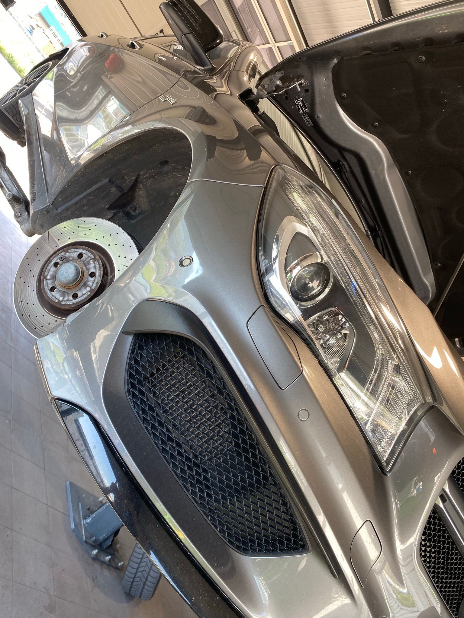 Un gros plan de l'avant d'une voiture dans un garage.