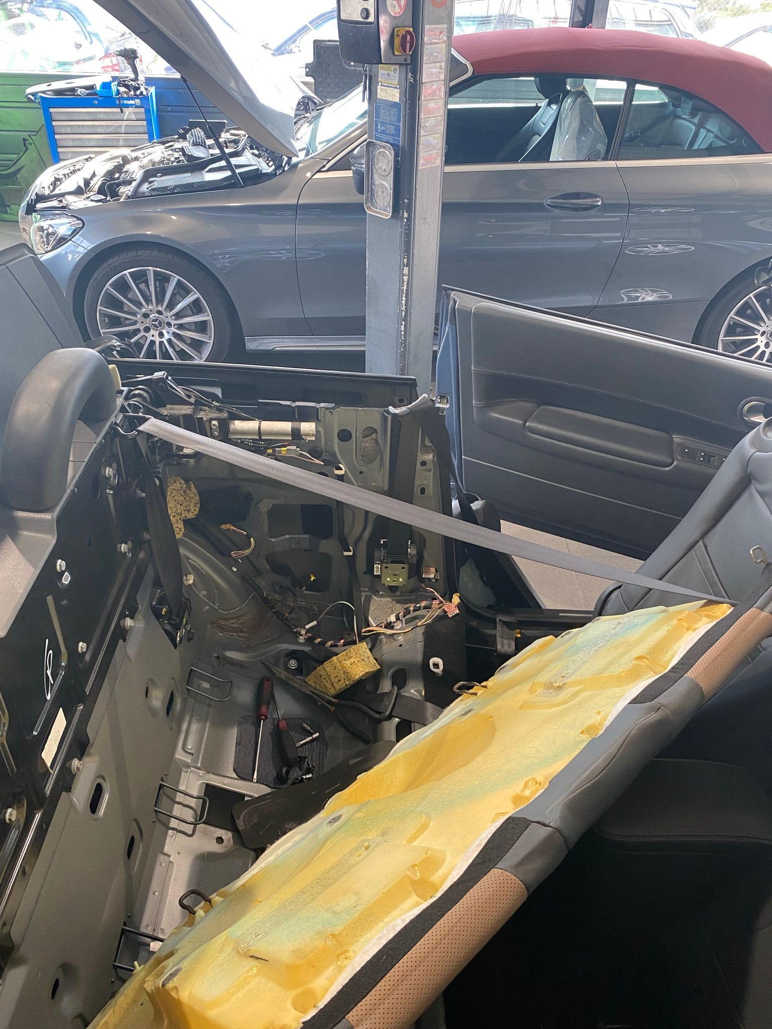 Une voiture est en cours de démontage dans un garage.