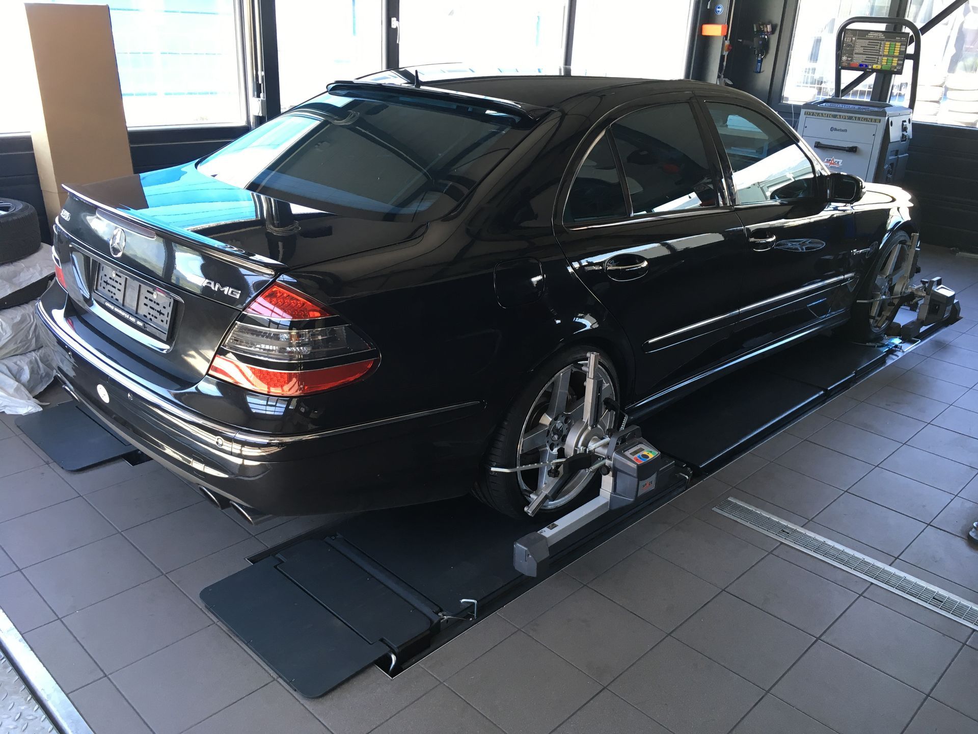 Une voiture noire est assise sur un ascenseur dans un garage.
