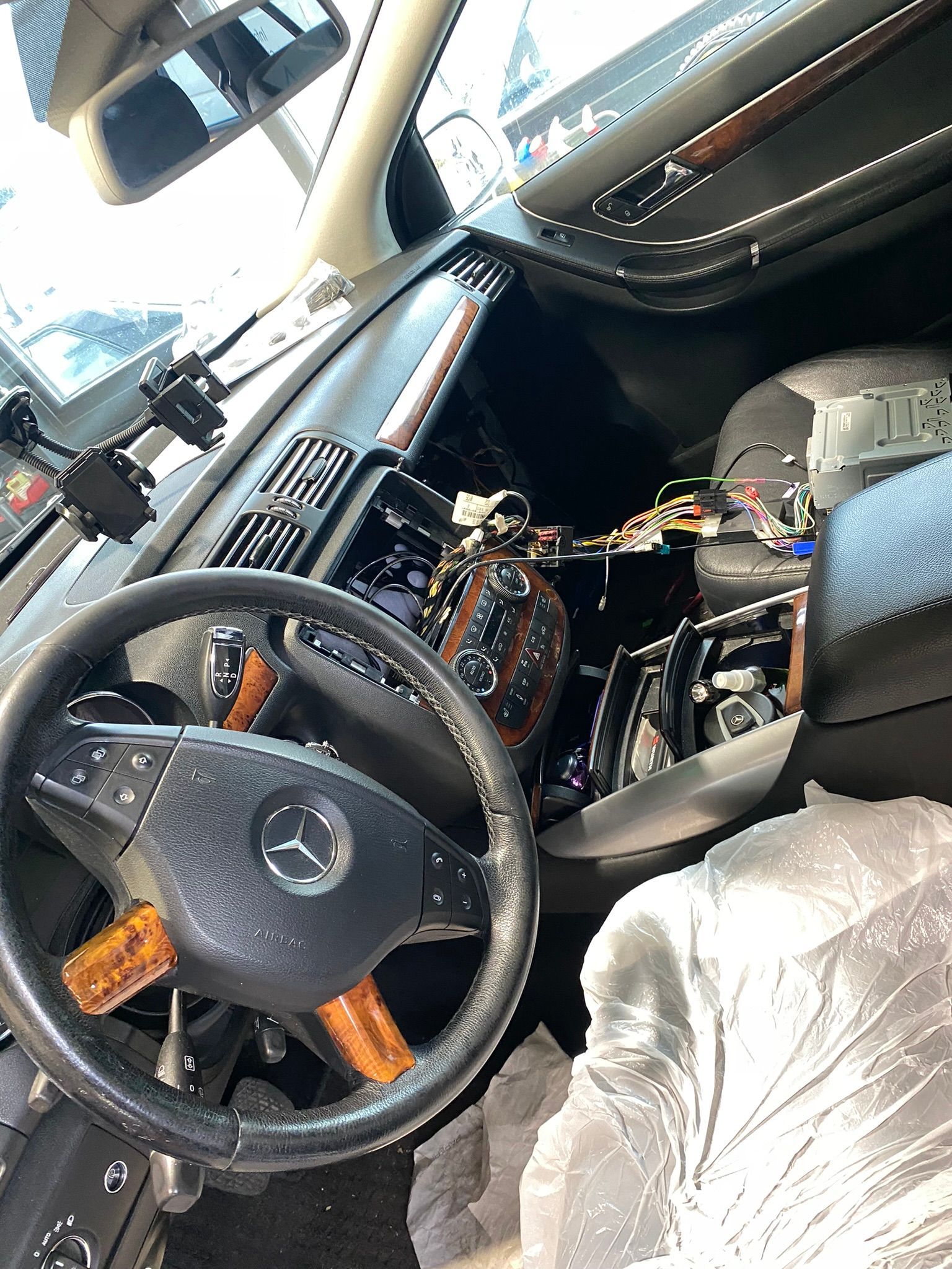 L’intérieur d’une voiture avec volant et tableau de bord recouverts de plastique.