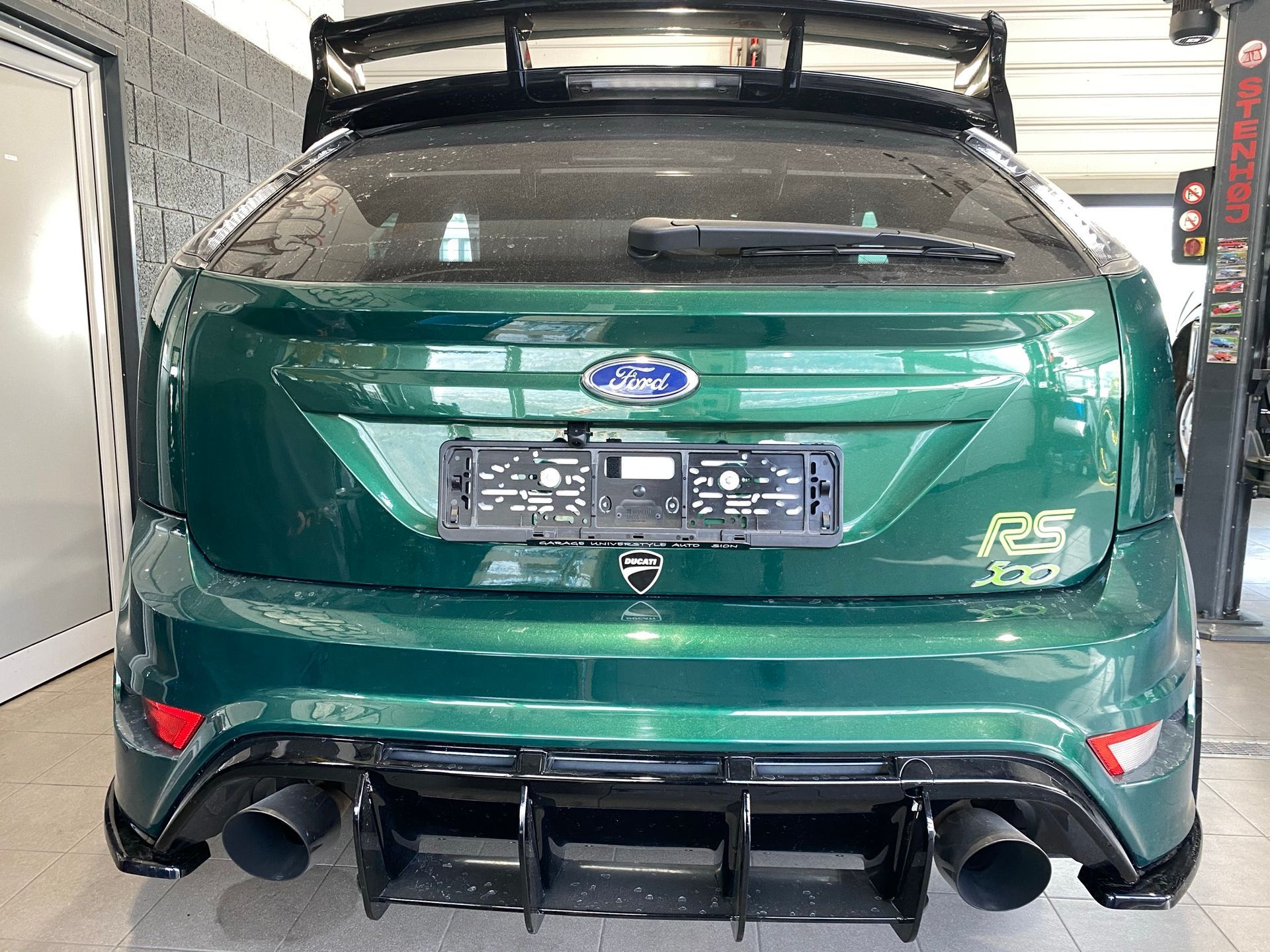 Une Ford Focus RS verte est garée dans un garage.
