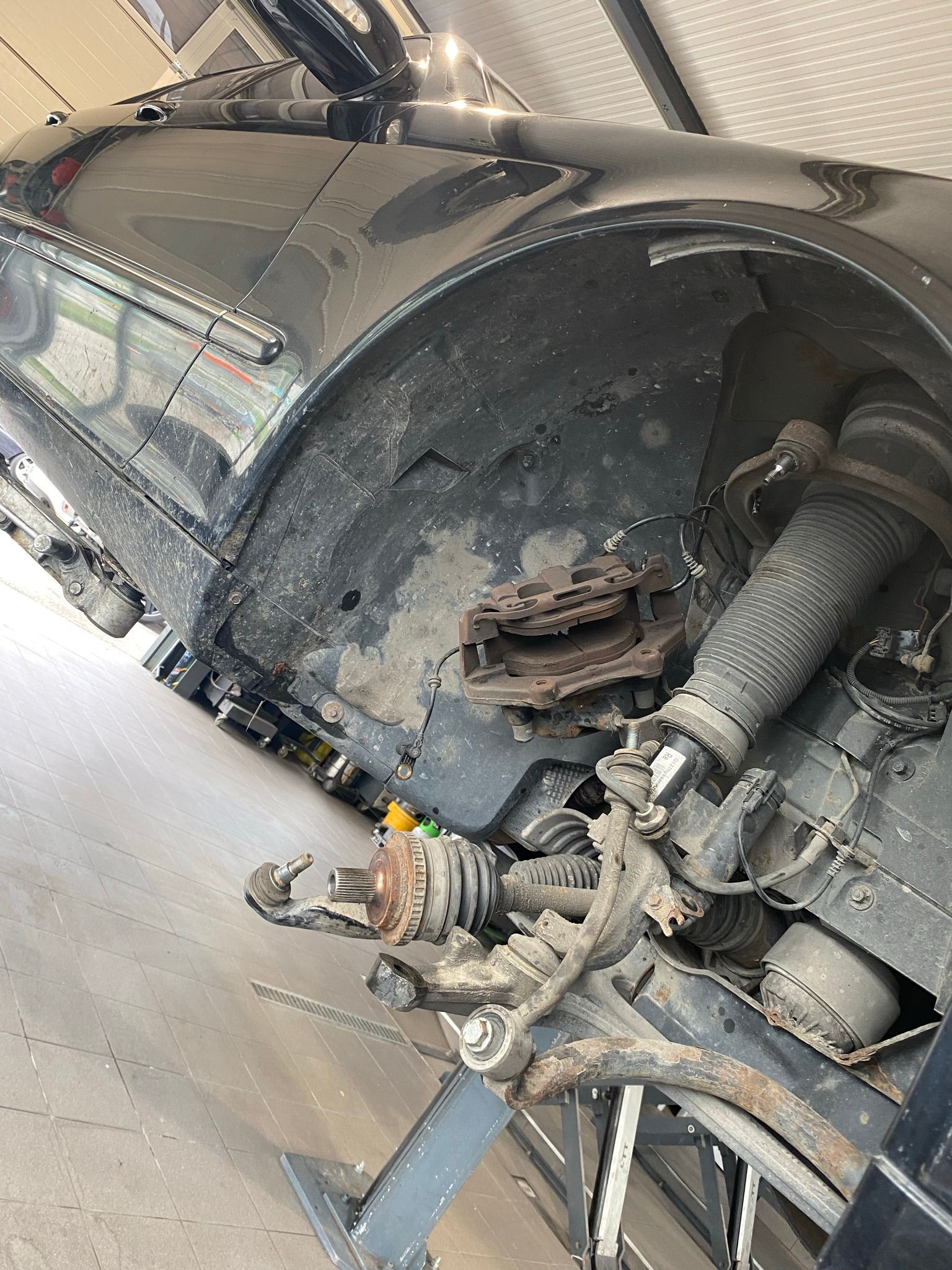 Une voiture est posée sur un ascenseur dans un garage.