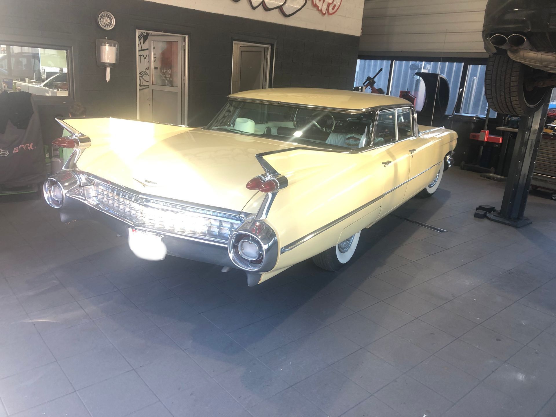 Une Cadillac jaune est garée dans un garage.