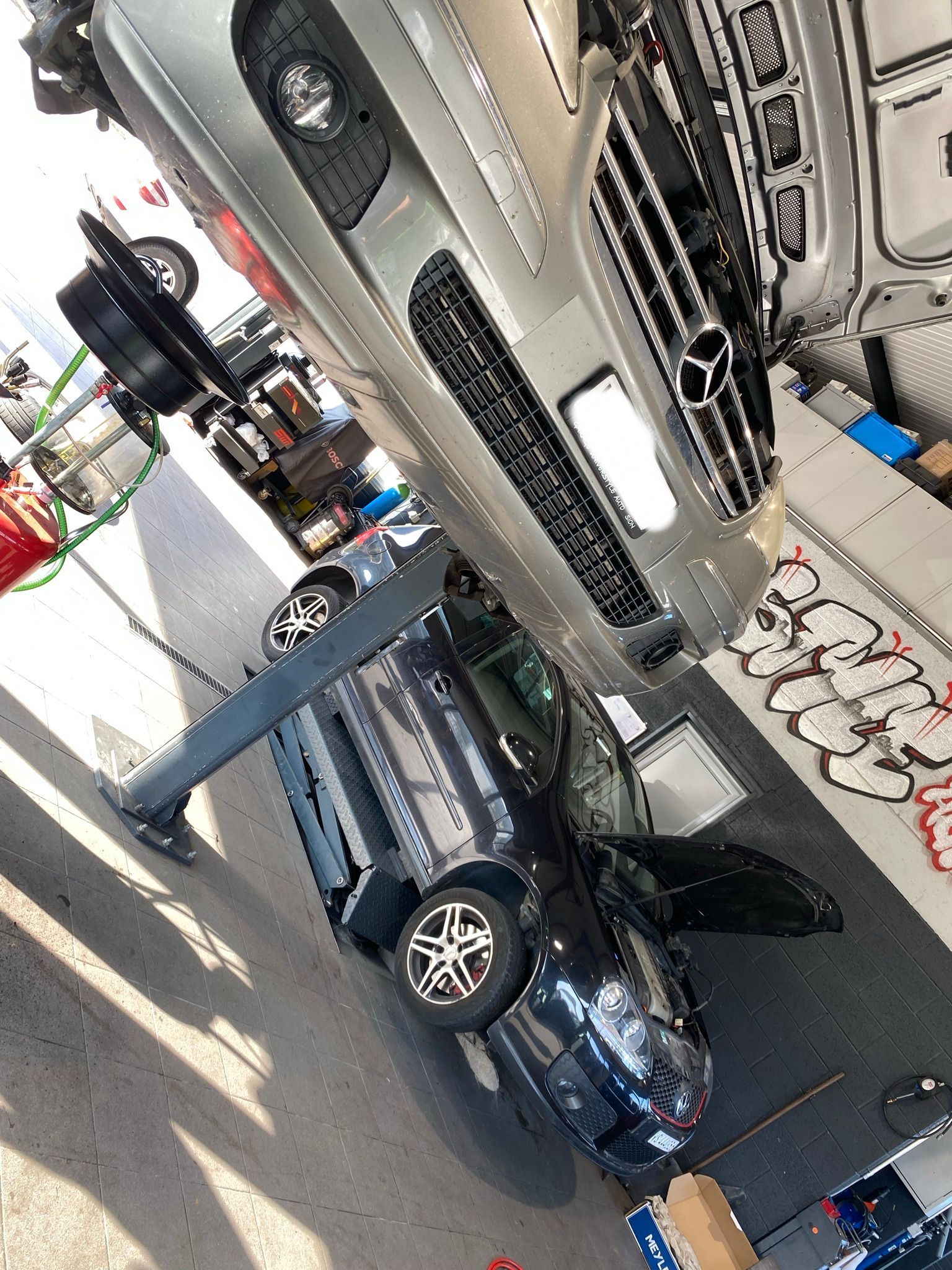 Une voiture est posée sur une autre voiture dans un parking.