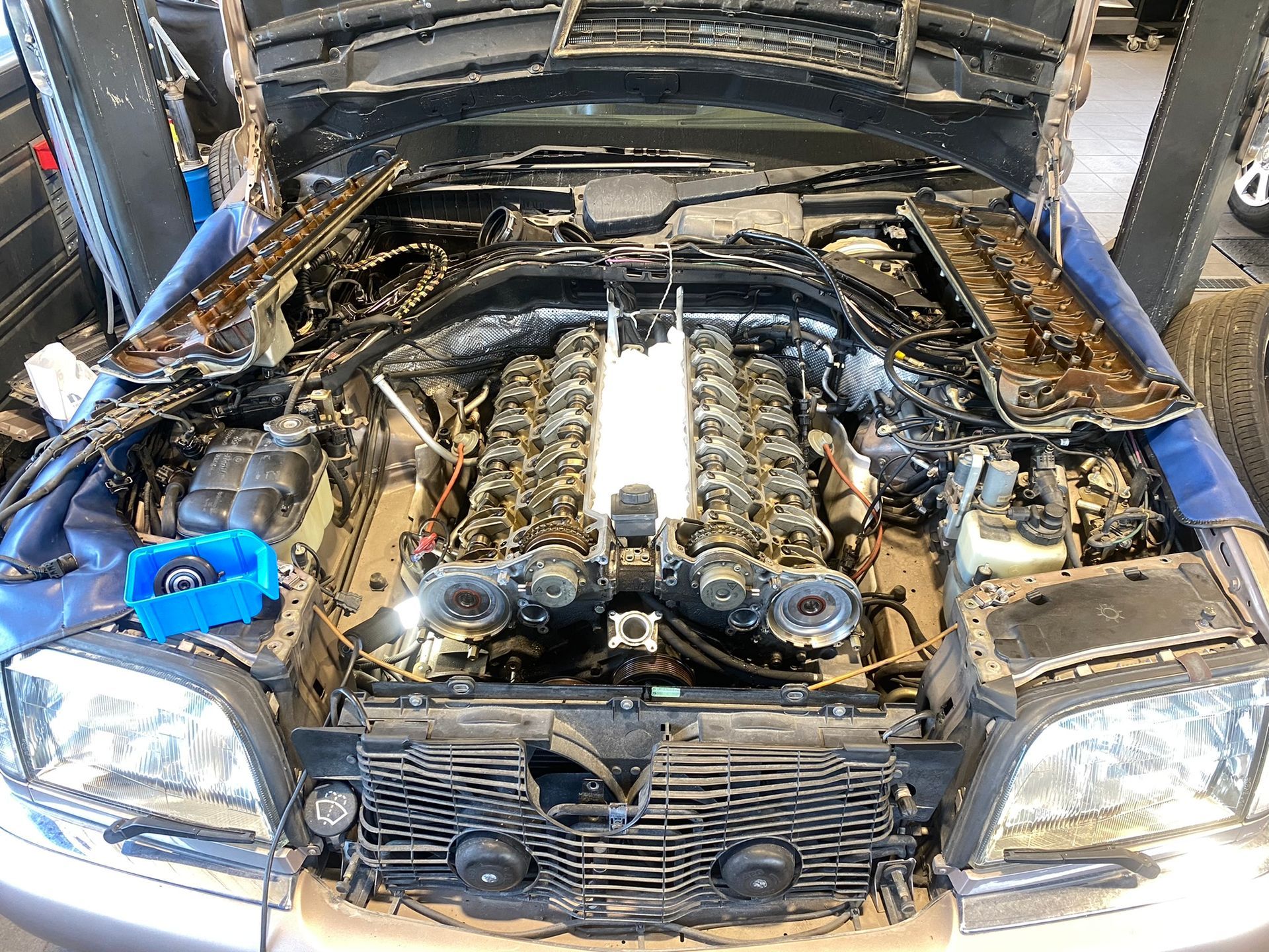 Le moteur d'une voiture avec le capot ouvert dans un garage.