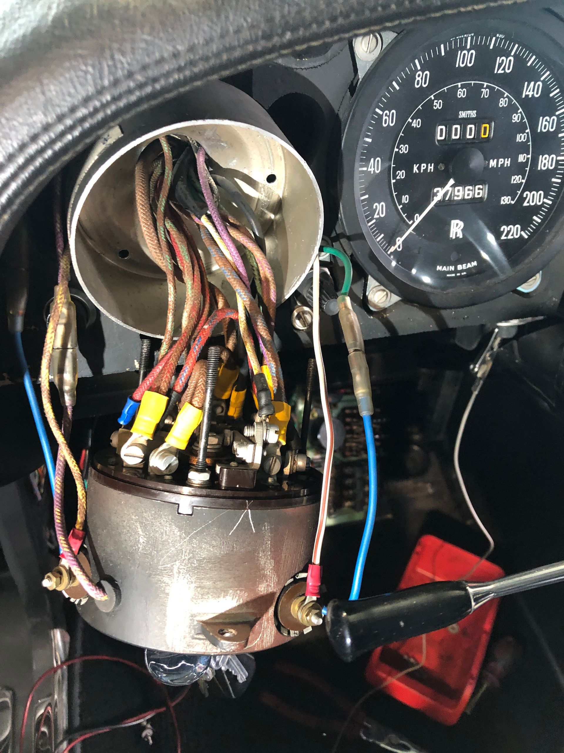 Un gros plan d'un tableau de bord avec un compteur de vitesse et un tas de fils