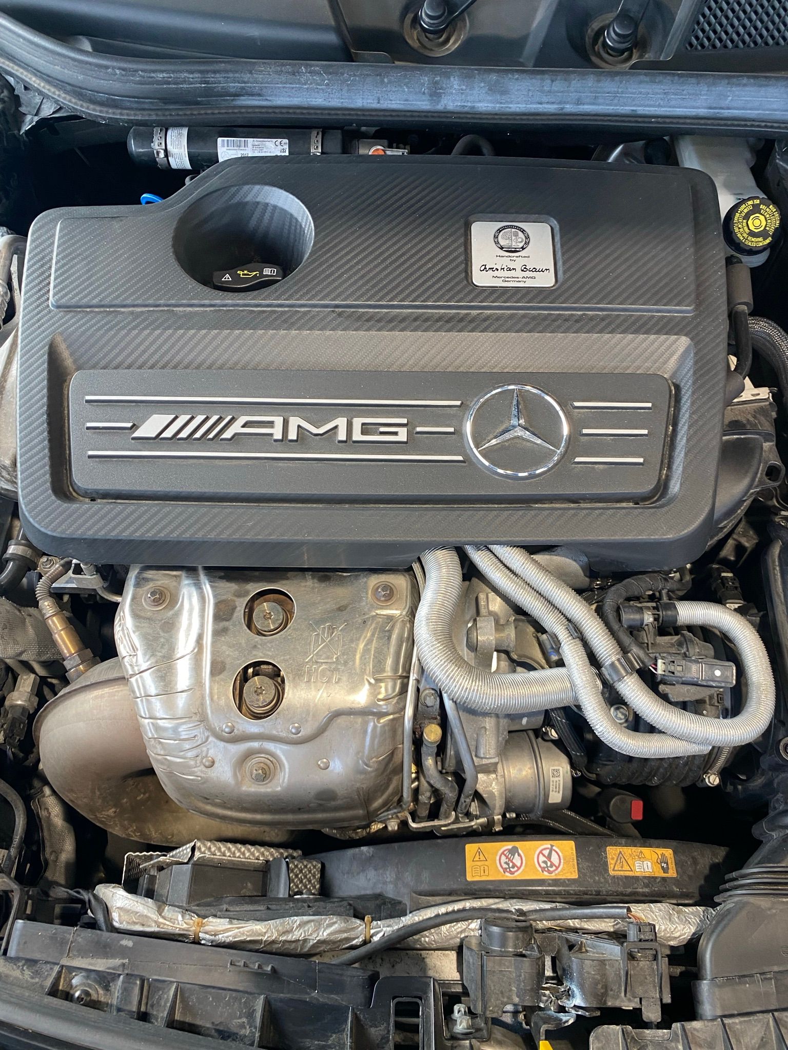 Un gros plan du moteur d’une voiture avec le capot ouvert.